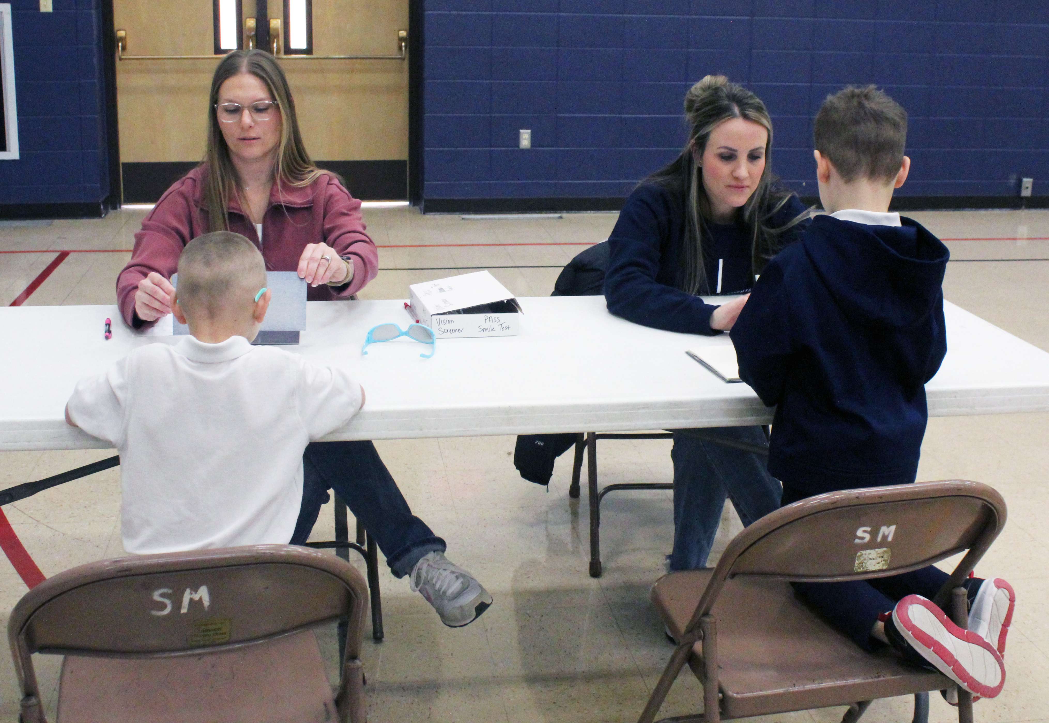 Lions volunteers test Holy Family Elementary School students for color blindness during a recent vision screening at the school. Photo by Cristina Janney/Hays Post