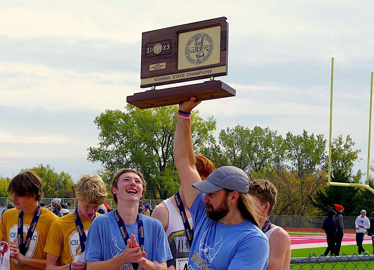 Ellinwood native Troy Prosser raises the state championship trophy after a successful 2023 cross country season. Prosser, who was recently named Class 2A Coach of the Year, has won four team championships at Central Heights.