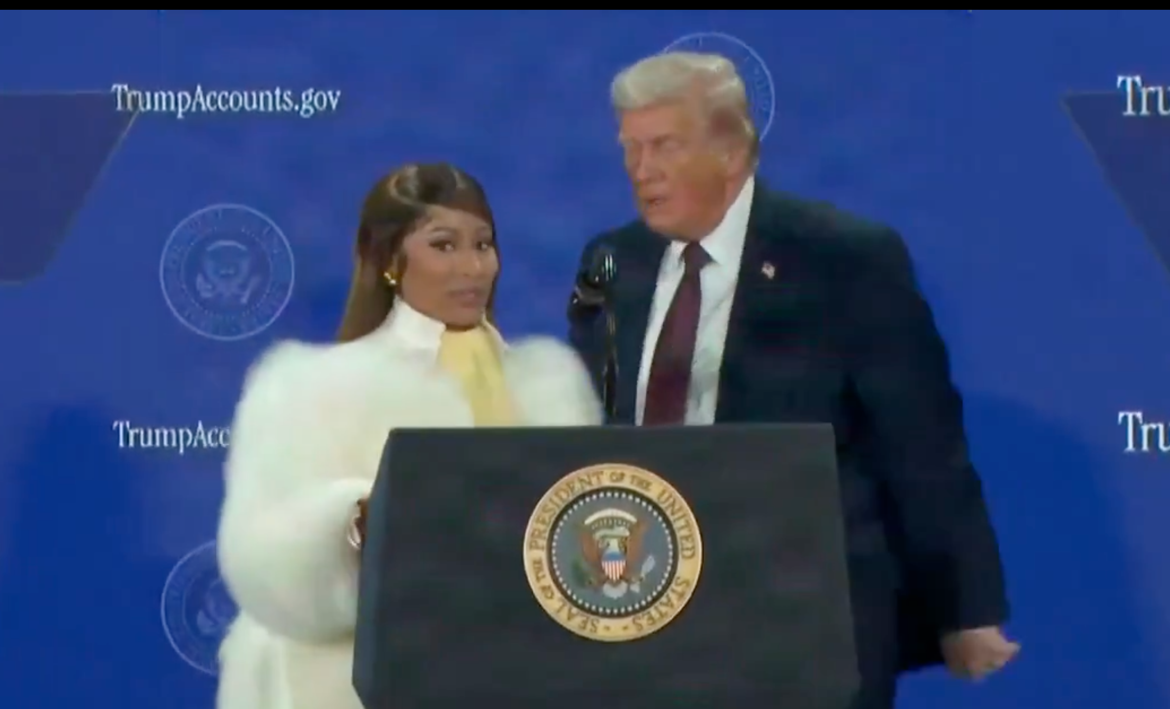 President Donald Trump celebrates the launch of “Trump Accounts” for newborn children. During the summit, President Trump was joined by rapper Nicki Minaj, who proclaimed herself “his number one fan.”-image from White House video