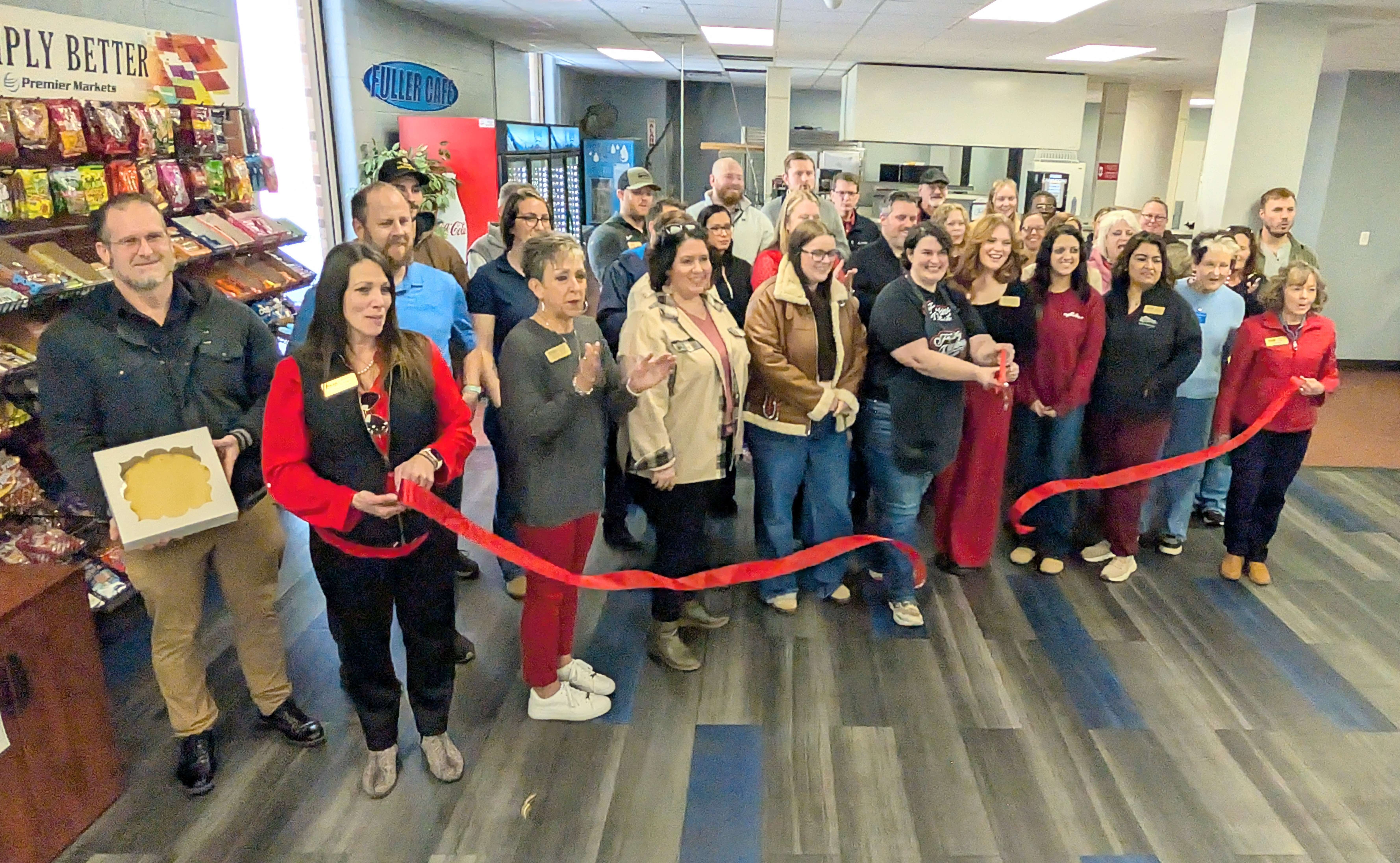 Great Bend Chamber of Commerce officials join Allie Cartwright, owner of Freaking Delicious Cheesecake, and others for a ribbon cutting Thursday morning marking her use of the kitchen at Fuller Industries.