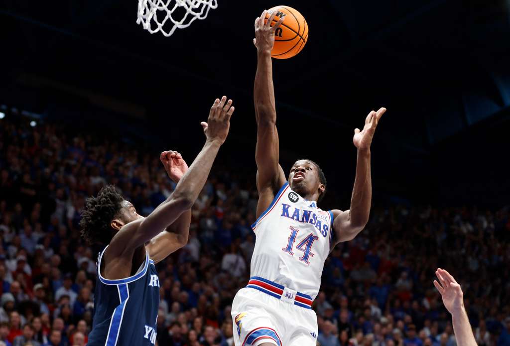 Kansas guard Melvin Council Jr. (14) goes yup to score as BYU forward AJ Dybantsa, left, defends during the first half of an NCAA college basketball game, Saturday, Jan. 31, 2026, in Lawrence, Kan. (AP Photo/Colin E. Braley)