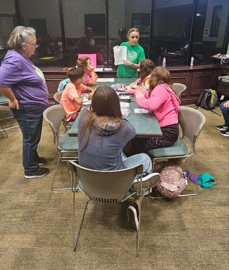 Girl Scout volunteers Amber Arnold ,center standing, and Karen Wilson, left standing, lead the Joint Ventures project with local Girl Scouts on Saturday at the Sternberg Museum. The Girl Scouts decorated butterflies and wrote notes in Spanish to students in Mexico, where the monarch butterflies migrate. Courtesy photo
