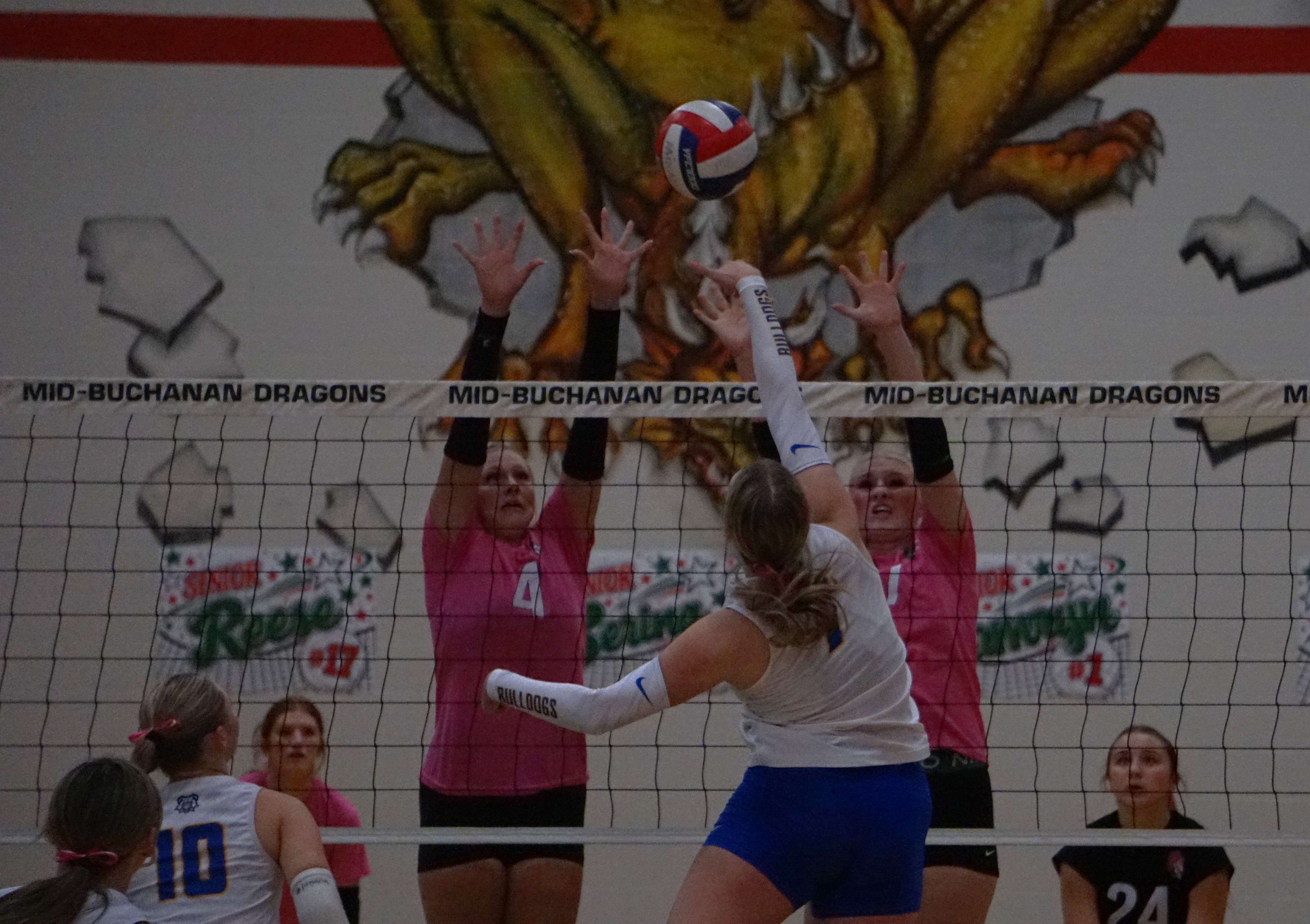 East Buchanan's Ellyonna Conard (7) goes to spike the ball against a Mid-Buchanan wall/ Photo by Matt Pike