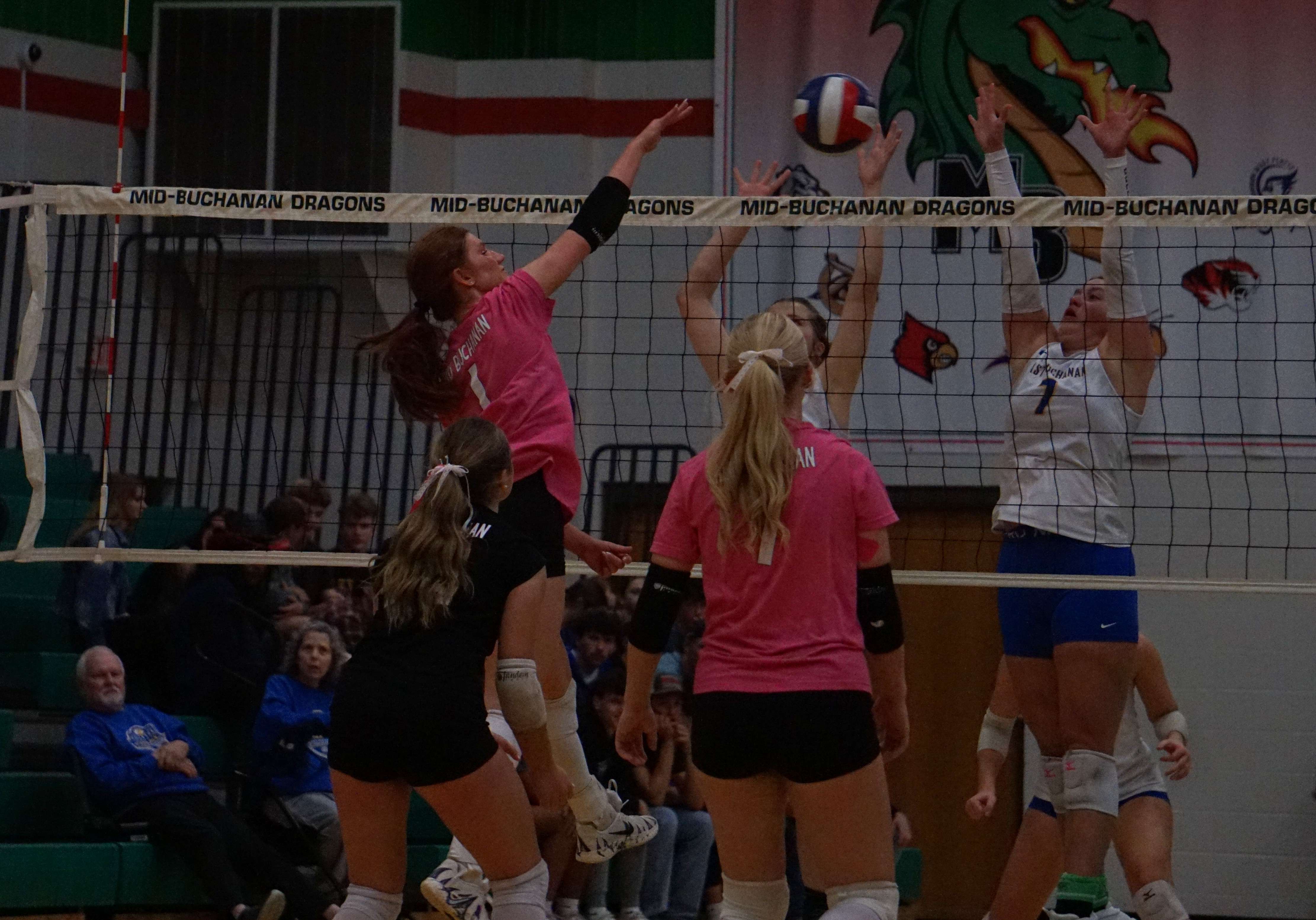 Mid-Buchanan's Camryn Atha (1) spikes the ball past the East Buchanan defense/ Photo by Matt Pike