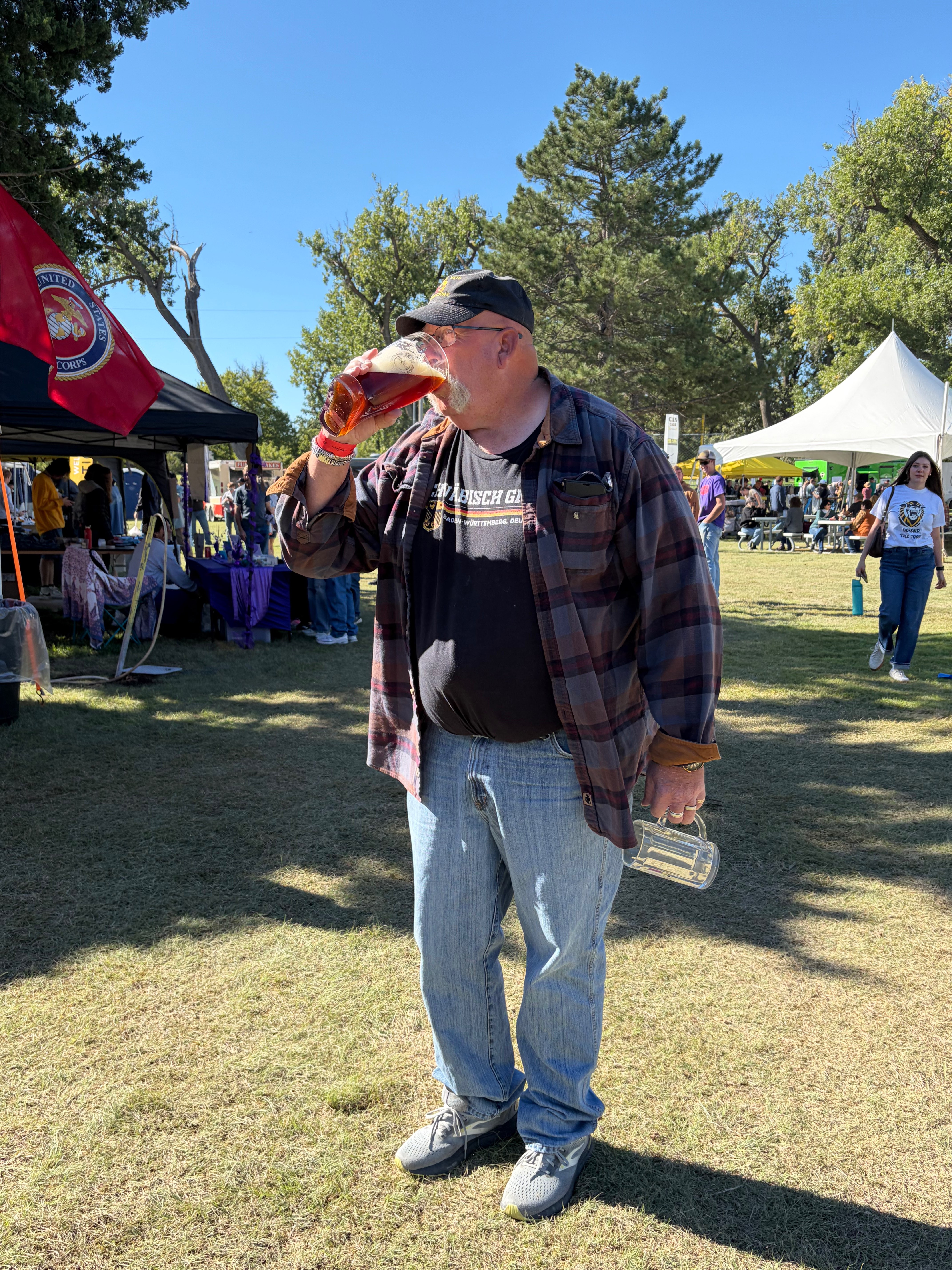 Oktoberfest goer drinking a German beer from a glass shoe at Oktoberfest Hays 2026. Photo by Alin Hett/Hays Post
