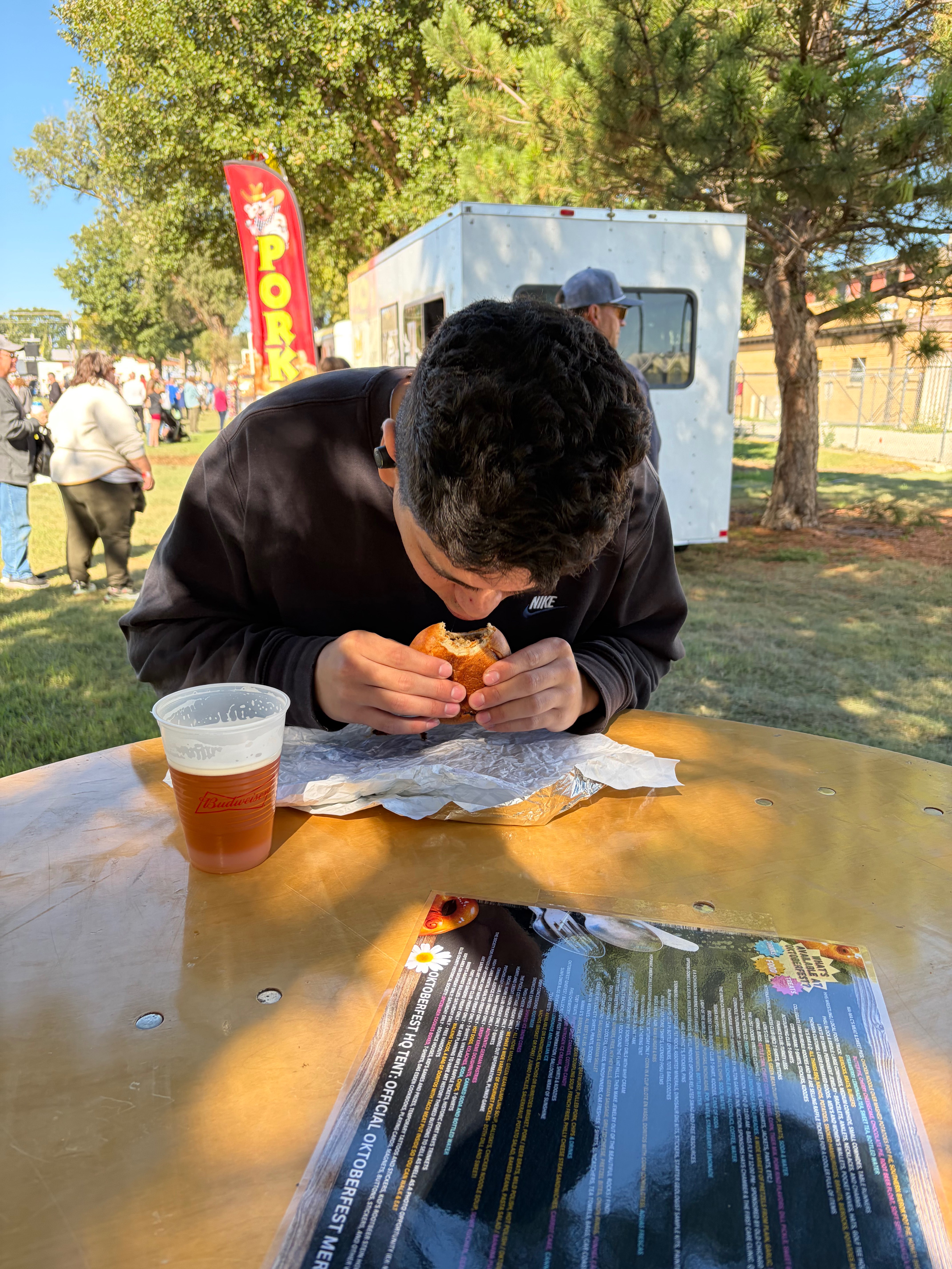 Oktoberfest goer takes a bite of a traditional German bierock at Oktoberfest Hays 2026. Photo by Alin Hett/Hays Post&nbsp;