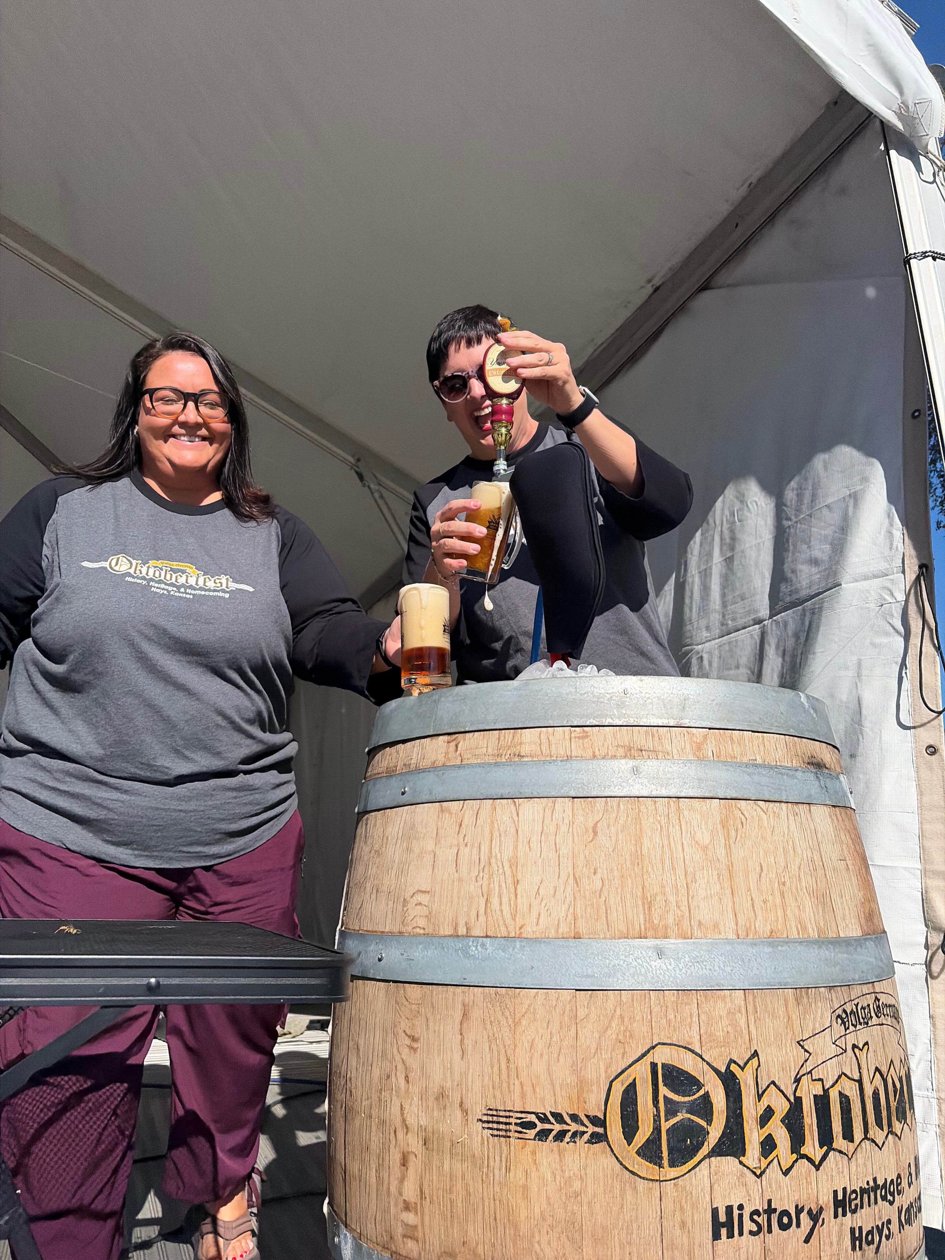Emily Knowles, Oktoberfest Hays 2026 director, and Amanda Rupp, Ellis County Historical director, tap the keg during Oktoberfest Hays 2026. Photo by Alin Hett/Hays Post&nbsp;