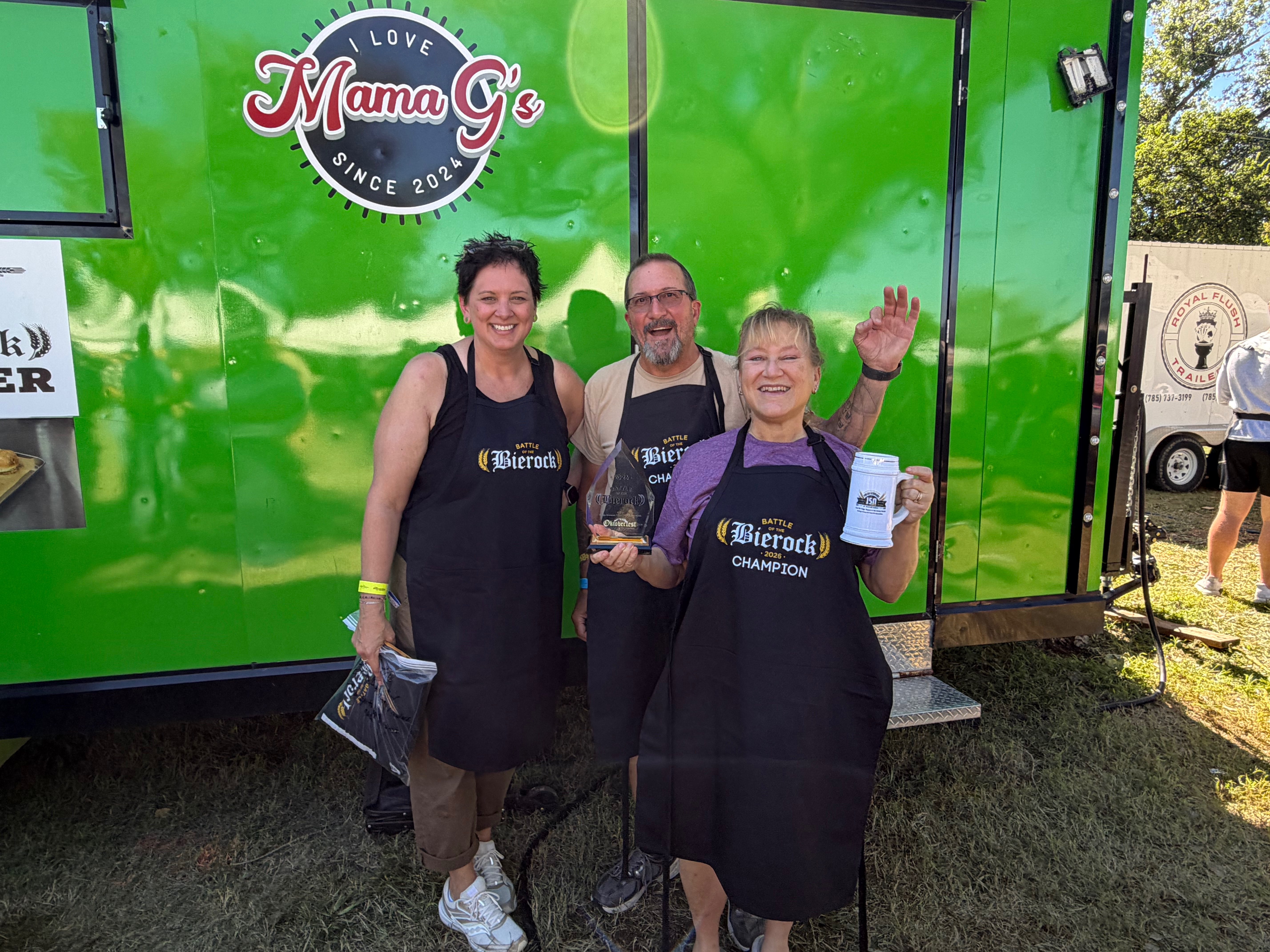 Amanda Rupp (left), Ellis County historical director, poses with the winners of the 2026 Bierock competition Dave Givens (middle) and Owner of Mama G's Gina Givens (right) at Oktoberfest Hays 2026. Photo by Alin Hett/Hays Post&nbsp;