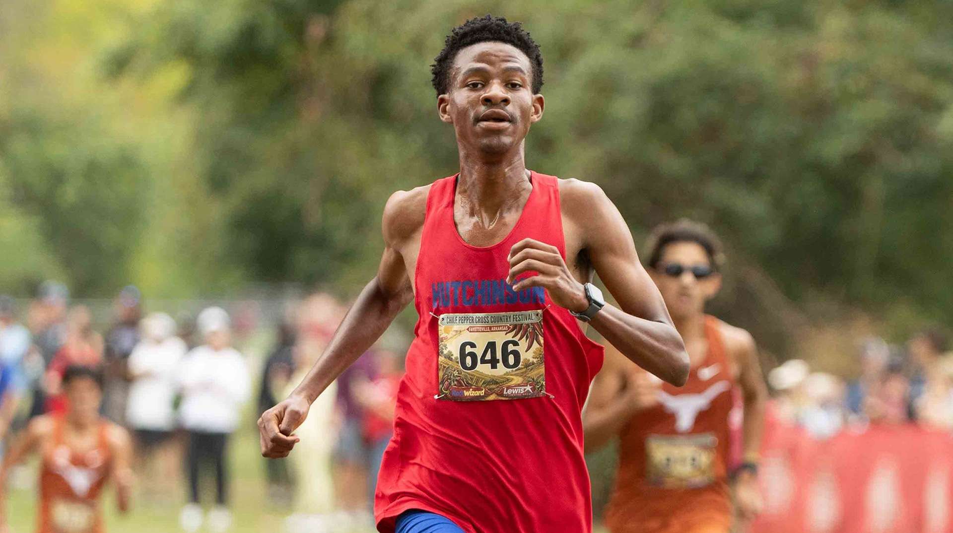 Blue Dragon freshman Letsepa Prince Madume runs down the final stretch past two University of Texas runners to place fifth overall in the Chile Pepper Festival on Saturday in Fayetteville, AR. Madume was named the USTFCCCA NJCAA Division I National Athlete of the Week on Monday. (Photo courtesy Ed Bailey)