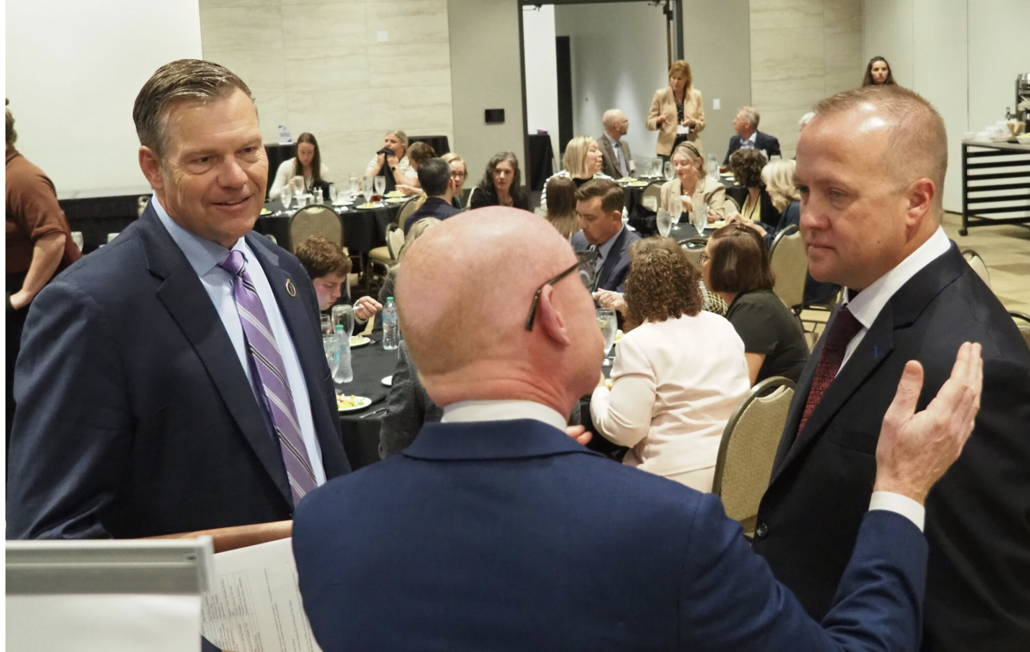 Republican Attorney General Kris Kobach, left, chats with Democratic Party nominee Chris Mann prior to a campaign debate sponsored by the Johnson County Bar Association. The candidates, who faced off in the 2022 election, will learn their fate on Nov. 3. (Photo by Tim Carpenter/Kansas Reflector)