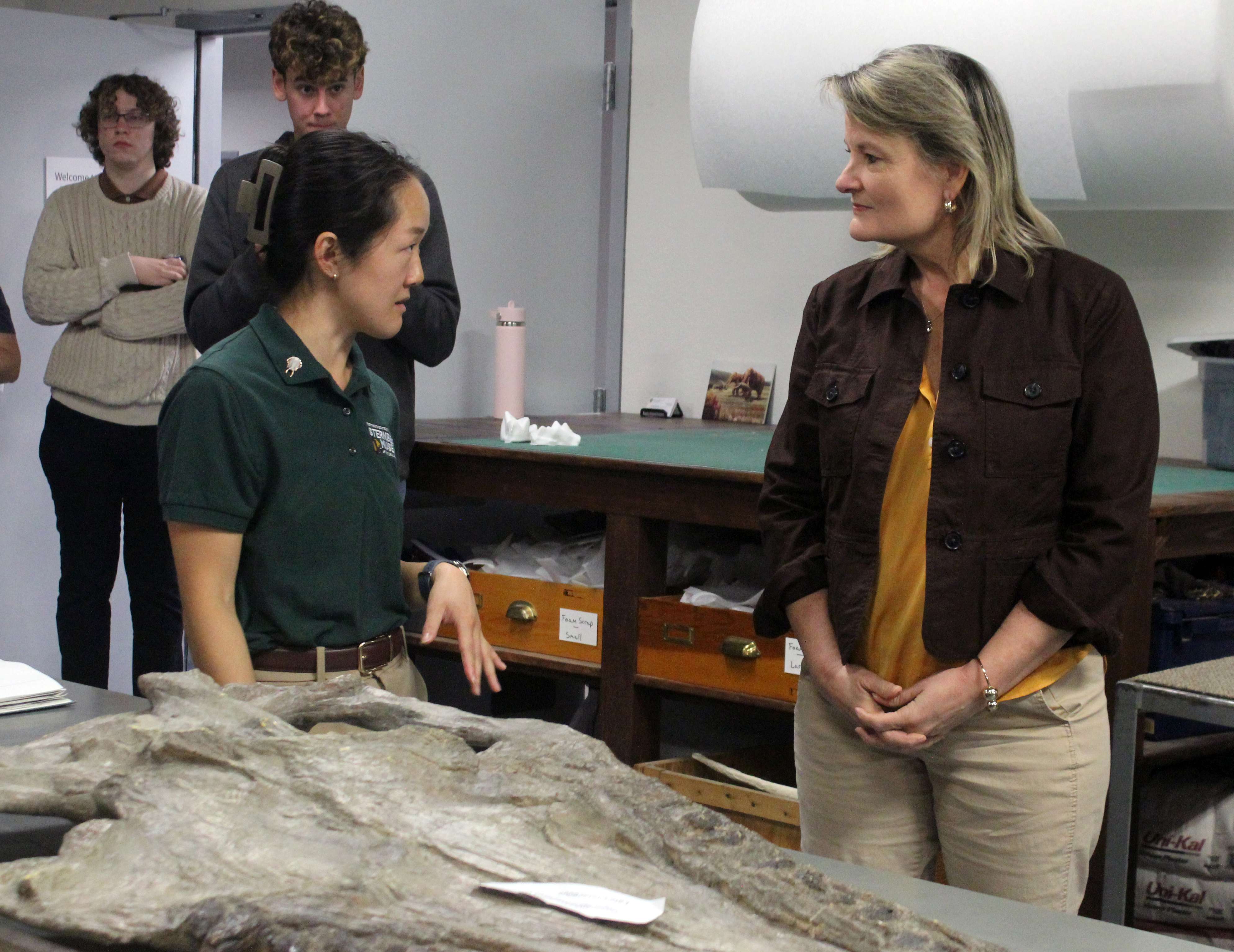Amanda Peng, curator of paleontology and geology at the Sternberg Museum of Natural History, left, speaks with Democratic gubernatorial candidate Cindy Holscher, right, about the importance of the museum's collections during a tour on Sunday. The museum may forced to close in part because of state budget cuts. Photo by Cristina Janney/Hays Post