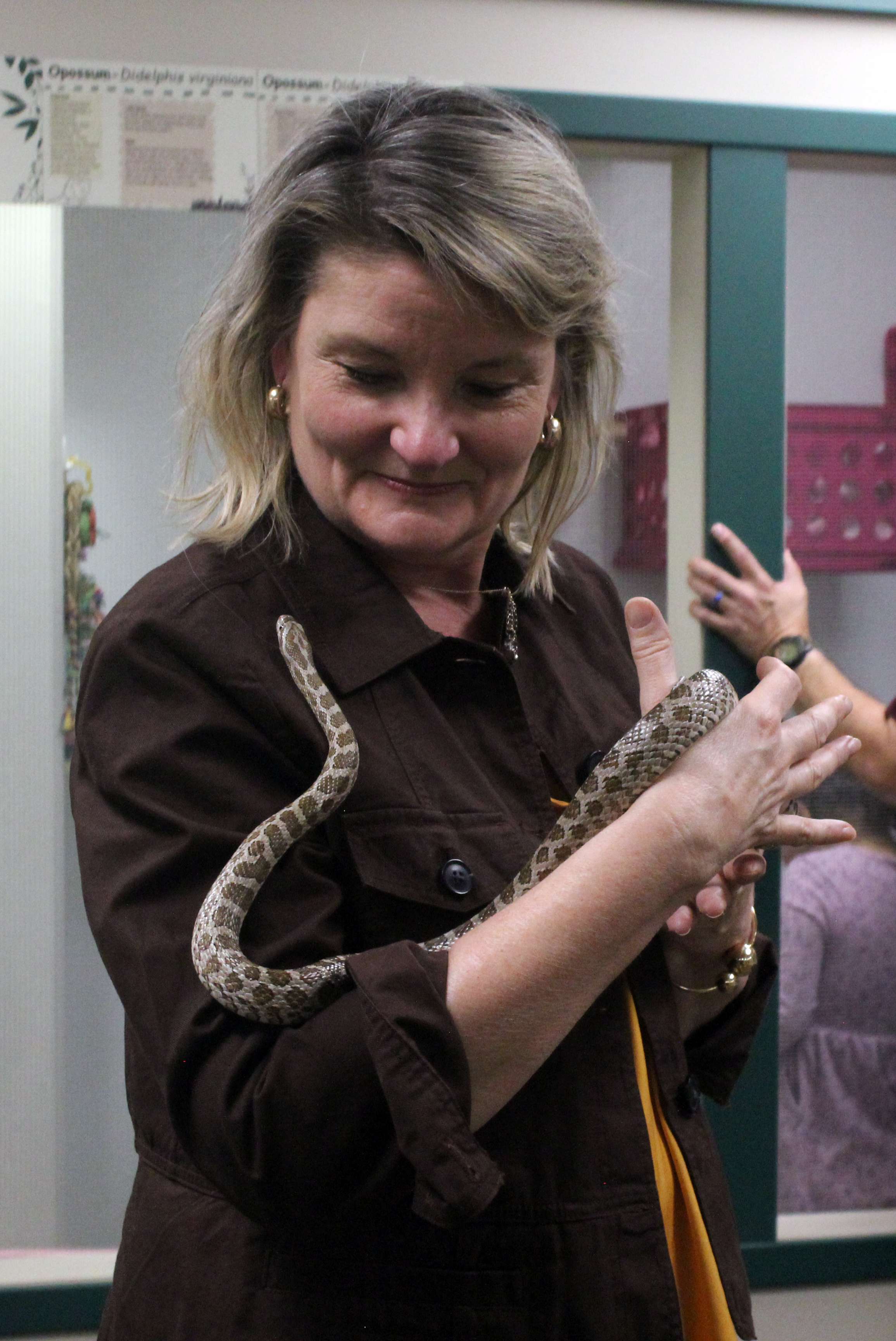 Holscher holds Hershey, a rat snake, at the Sternberg Museum on Sunday. during her stop in Hays she said she supported full funding of both public K-12 and higher education in the state. Photo by Cristina Janney/Hays Post