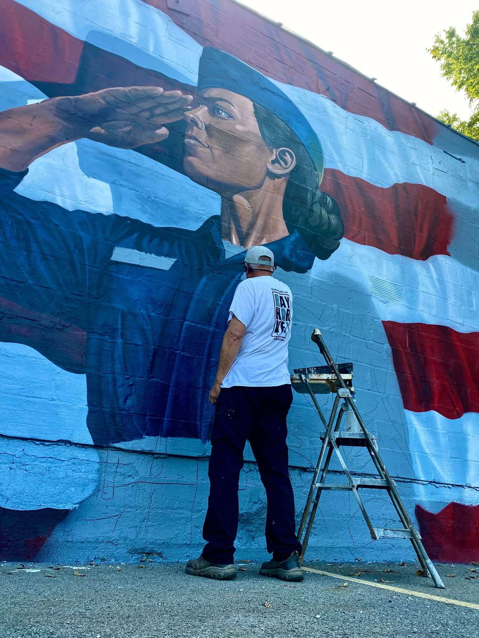 Artist Ray Harvey working on the mural in late September. Photo: Ray Harvey Art.