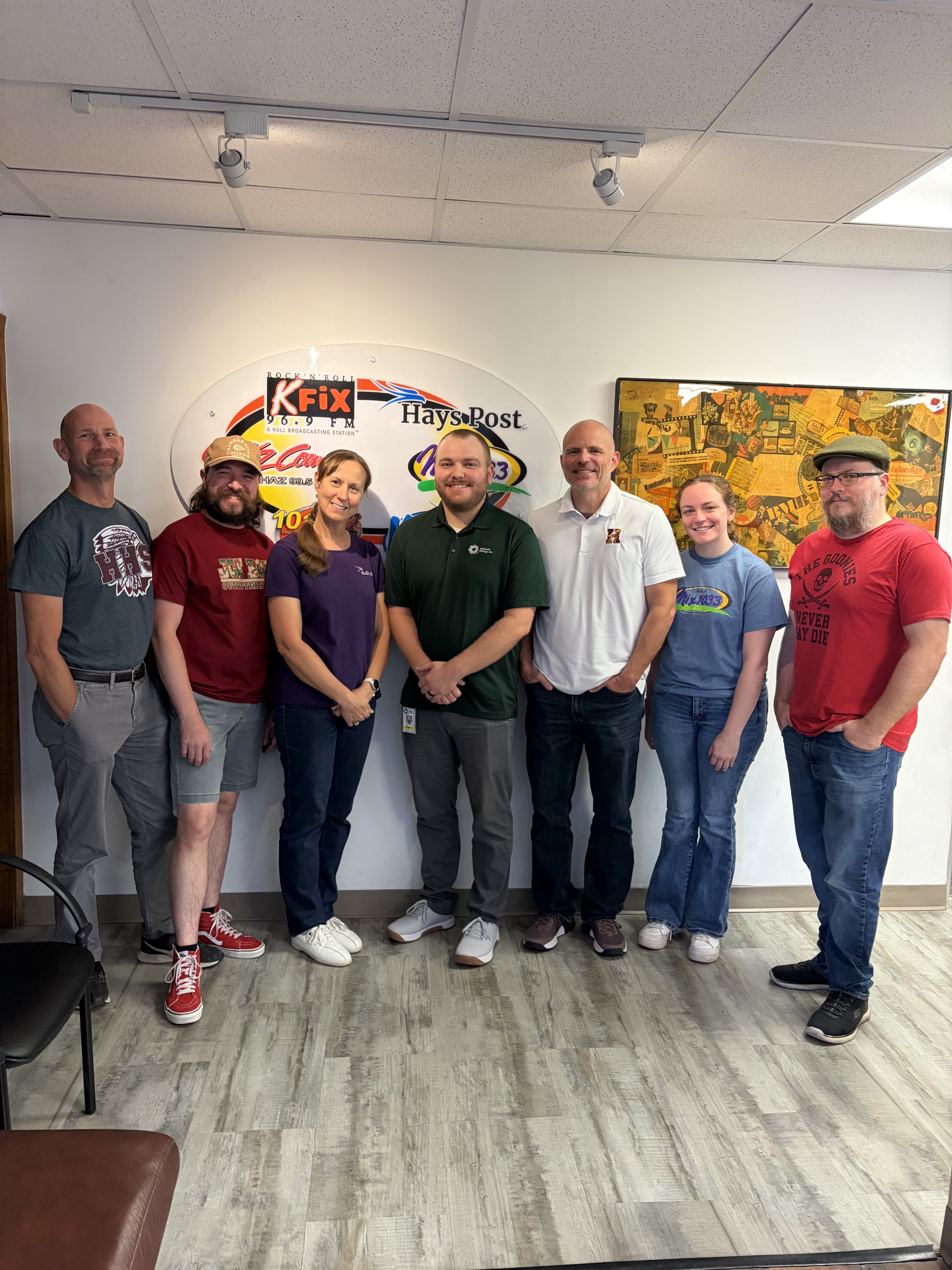 Blake Huxman is pictured with Eagle Media's on air personalities. From left: Mike Holliday, Joel Shorman, Theresa Trapp, Blake Huxman, Dustin Armbruster, Jami Morain and Jeff Leiker. Photo by Alin Hett/Hays Post. 
