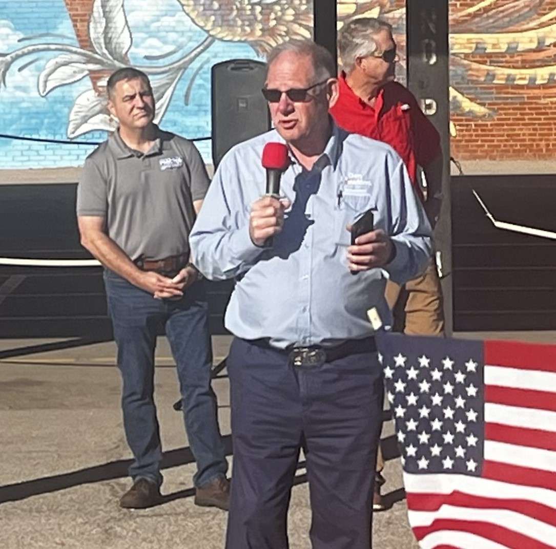 Pat Proctor (L) looks on as Dan Hawkins addresses attendees at the GOP bus stop in Hutchinson. (Hutch Post photo)