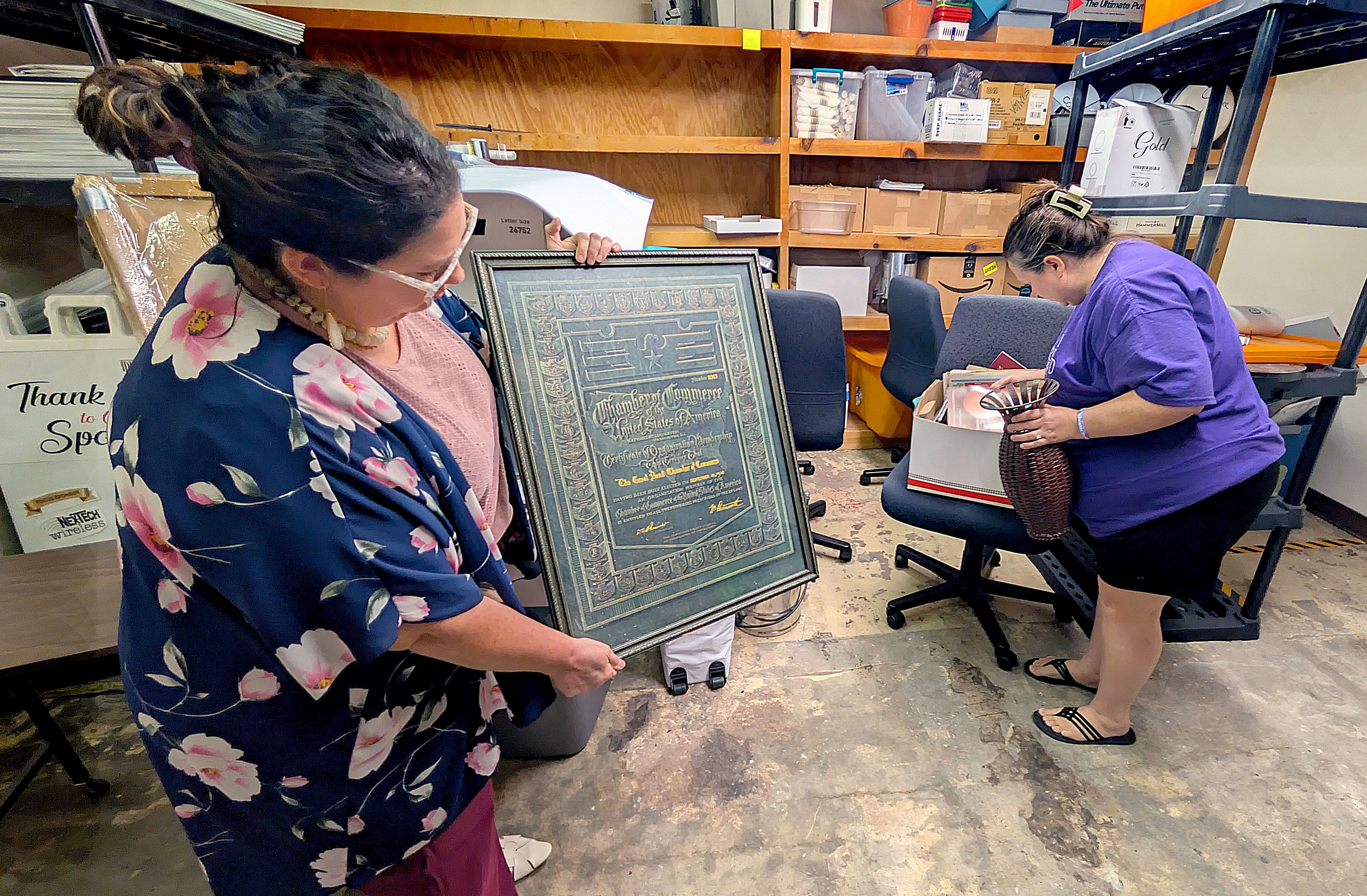 Megan Barfield, Chamber president and chief executive officer, left, and Ashley Hickman, chamber marketing director, sort through over a 100 years of Chamber history Tuesday morning as they prepare to relocate to the Innovation Center.