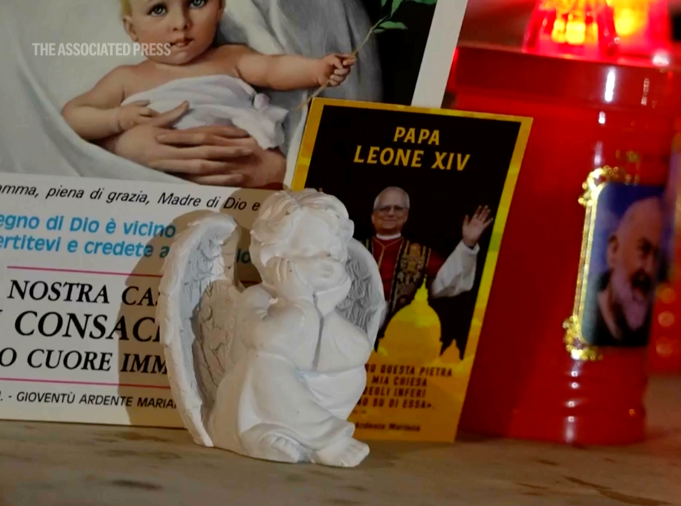 An image of Pope Leo XIV rests at the base of a statue of the late Pope John Paul II outside the Agostino Gemelli Polyclinic, where Leo is hospitalized for surgery to remove a lung nodule, in Rome, Tuesday, Oct. 13, 2026. (AP Photo/Gregorio Borgia)