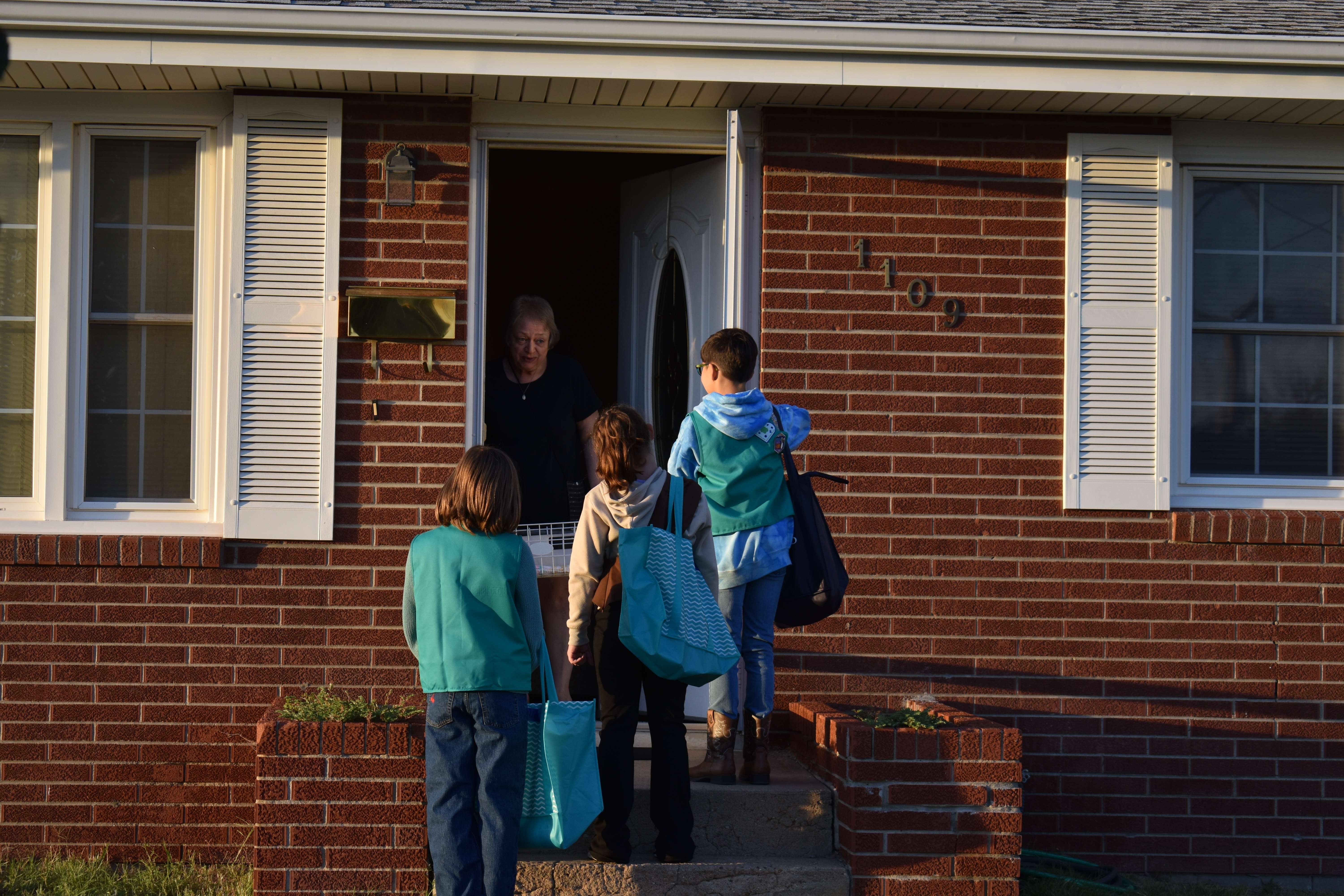 Local woman answers the door as Girl Scout Troop 10088 Trick or Treats for the Community Assistance Center's food bank. Residents were able to leave items on their porch if they weren't home or didn't want the doorbell rang. Photo by Jami Morain/Hays Post
