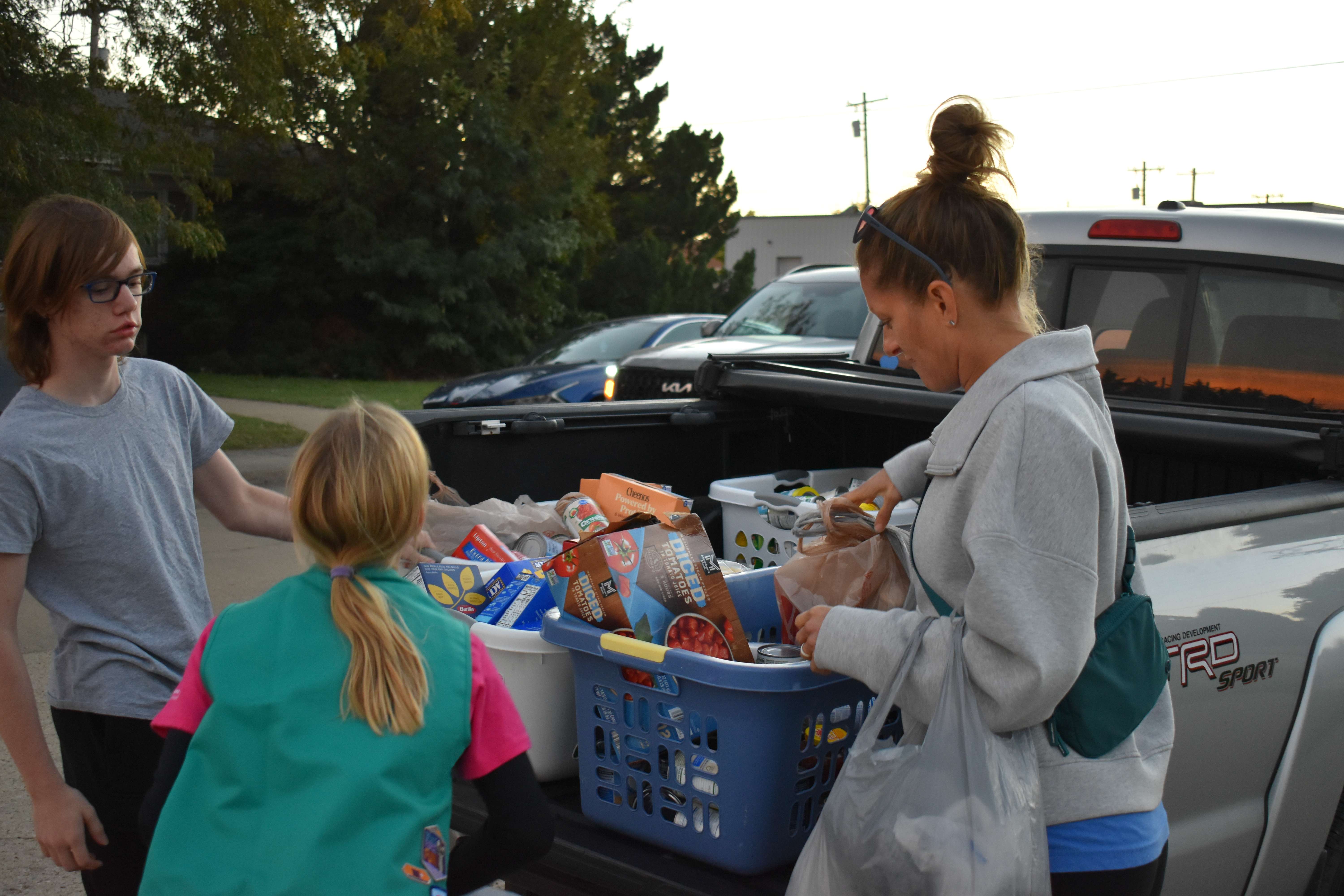Girl Scout Troop 10088 unloading their designated area collections into a volunteer's truck, who took them to the Community Assistance Center. Some volunteers drove back and forth to get the walking groups' donations back for sorting. Photo by Jami Morain/Hays Post
