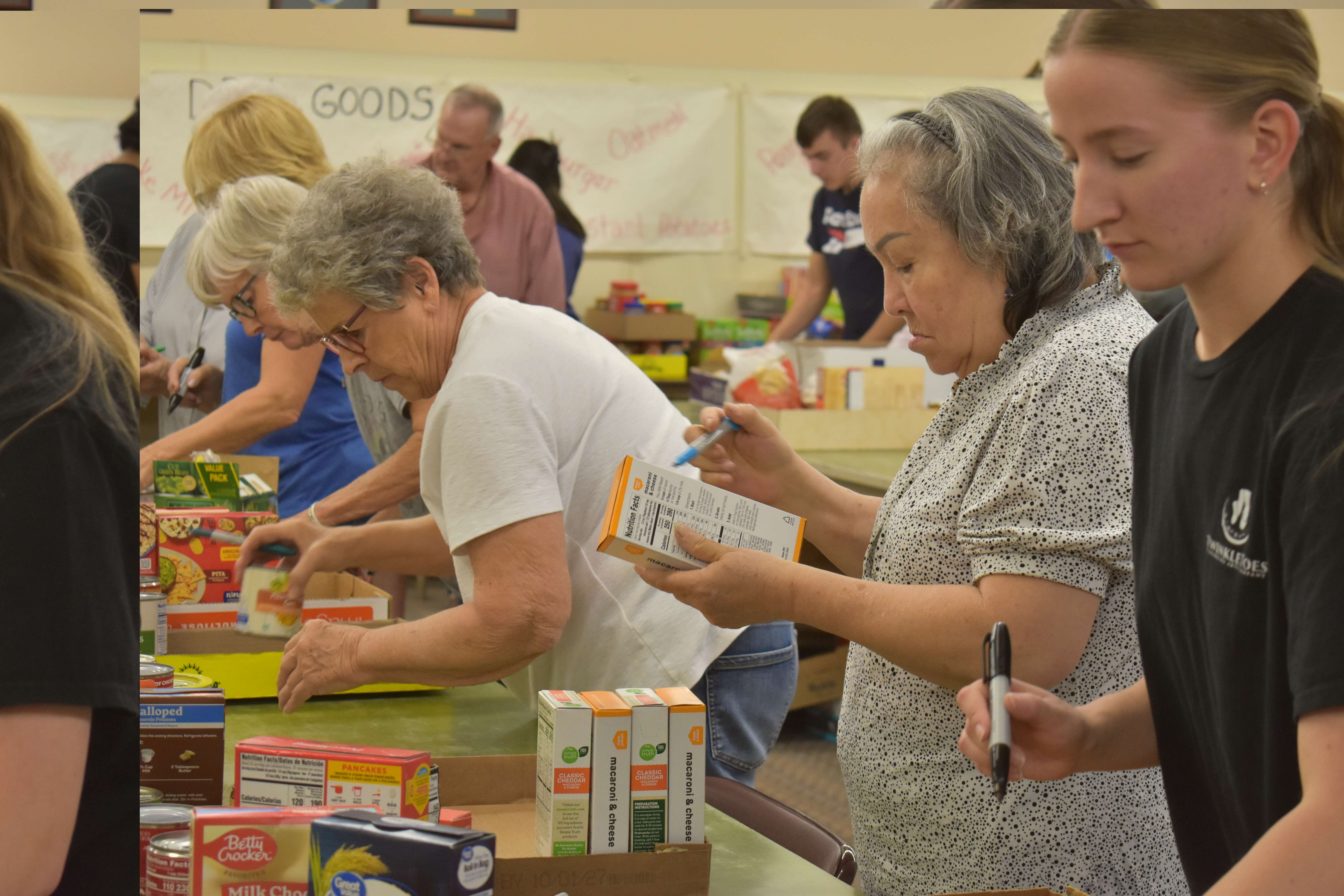 Community Assistance Center volunteers sort donations. Volunteers at the Center had to go through every bag and sort each individual item. Photo by Jami Morain/Hays Post