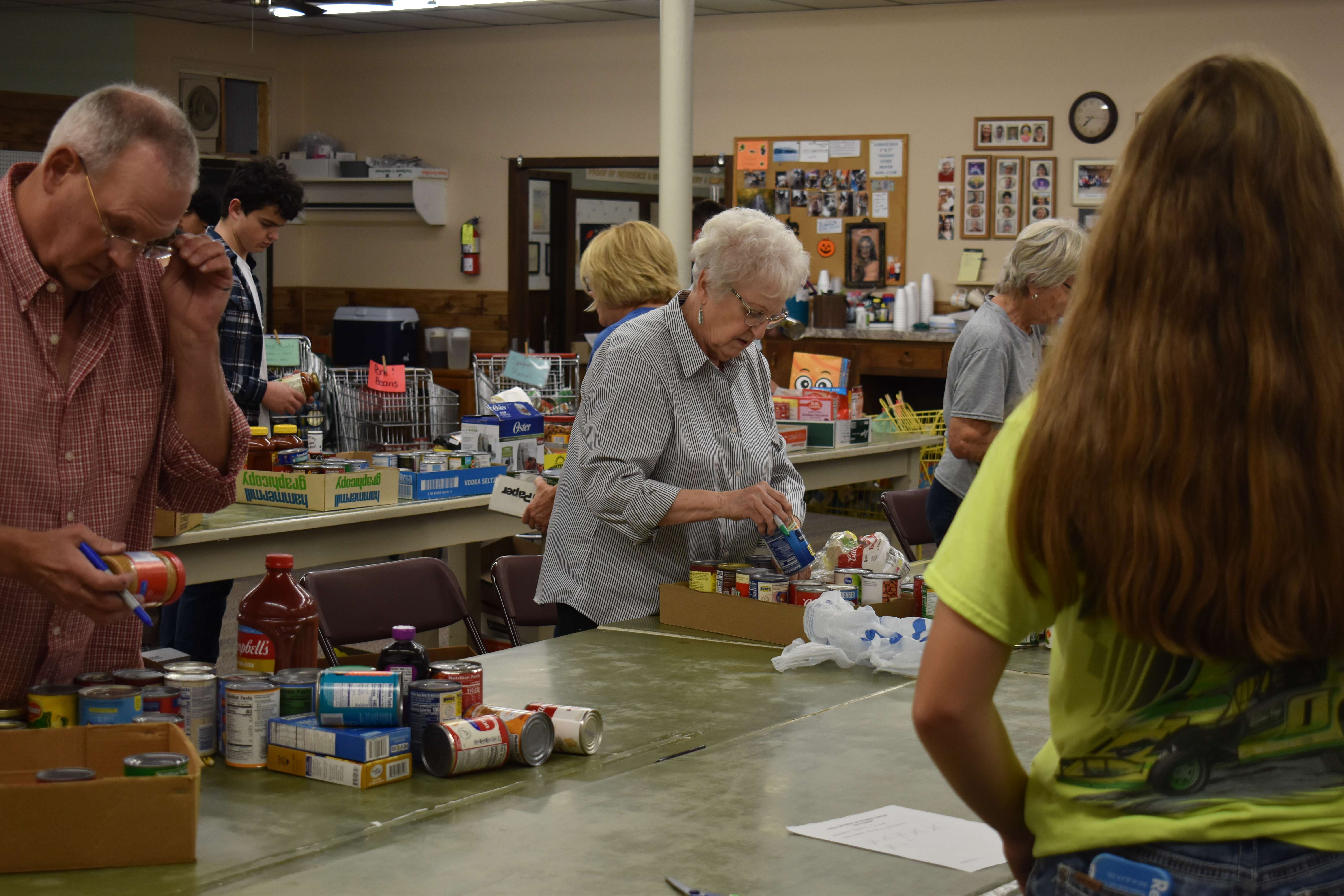 Food bank volunteers mark cans. Volunteers lined rows of tables to mark and sort non-perishable donations. Photo by Jami Morain / Hays Post