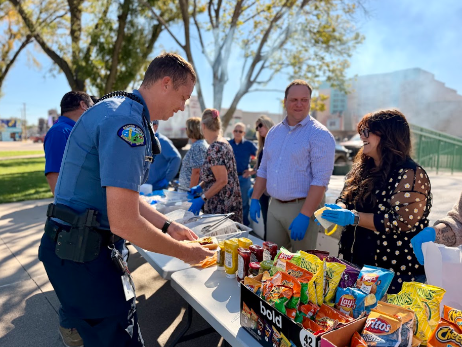 Employee Engagement Committee member Judith Castro serves lunch to a Barton County Sheriff’s Deputy during the annual Employee Picnic.
