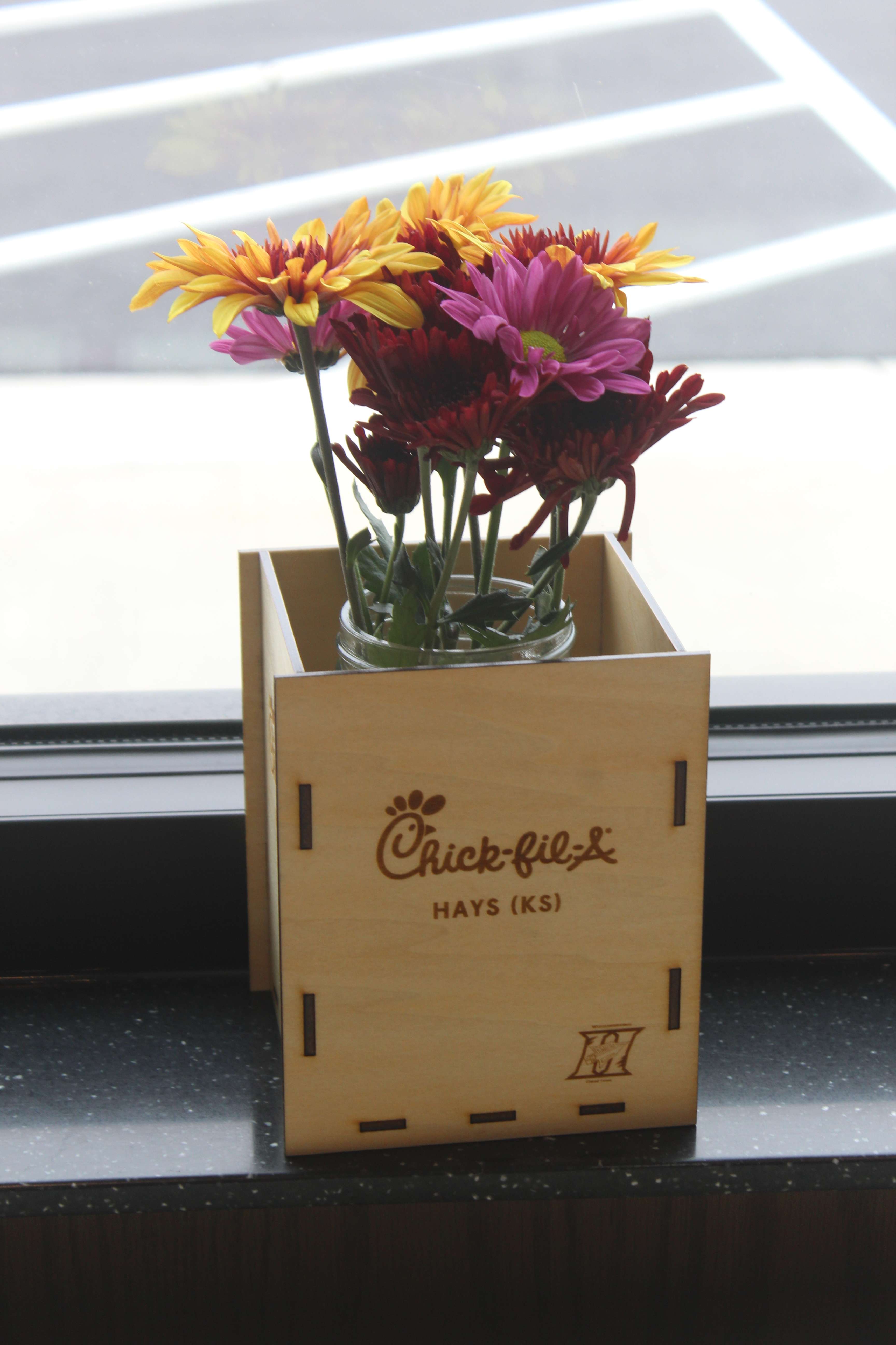 The Hays High School woodshop program made these decorative boxes for the Hays Chick-fil-A tables. Owner-operator Brett Pennell said he wants the store to be involved in the community. Photo by Cristina Janney/Hays Post