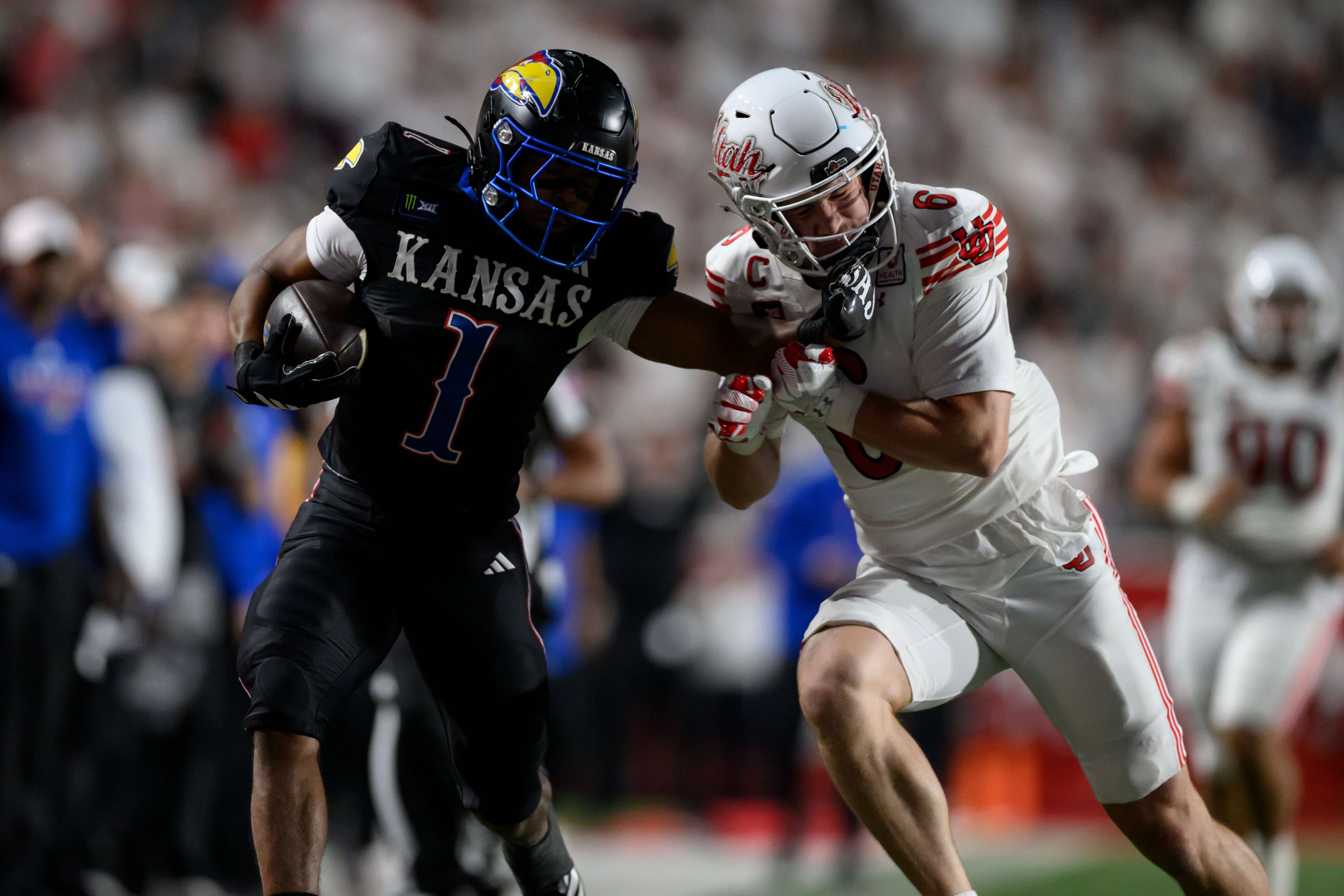 Kansas running back Dylan Edwards (1) runs the ball and stiff arms Utah safety Nate Ritchie (6) from making the tackle during the second half of an NCAA college football game, Saturday, Oct. 10, 2026, in Salt Lake City. (AP Photo/Tyler Tate)