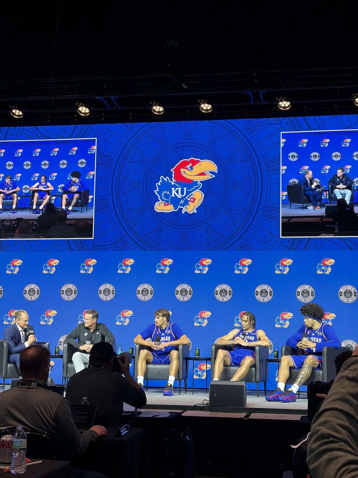 KU Basketball - 2026 Big 12 Media Day 1 in Kansas City - pictured left-to-right (head coach Bill Self, sophomore guard Kohl Rosario, senior forward Keanu Dawes (transfer from Utah) and freshman guard Tyran Stokes. 
