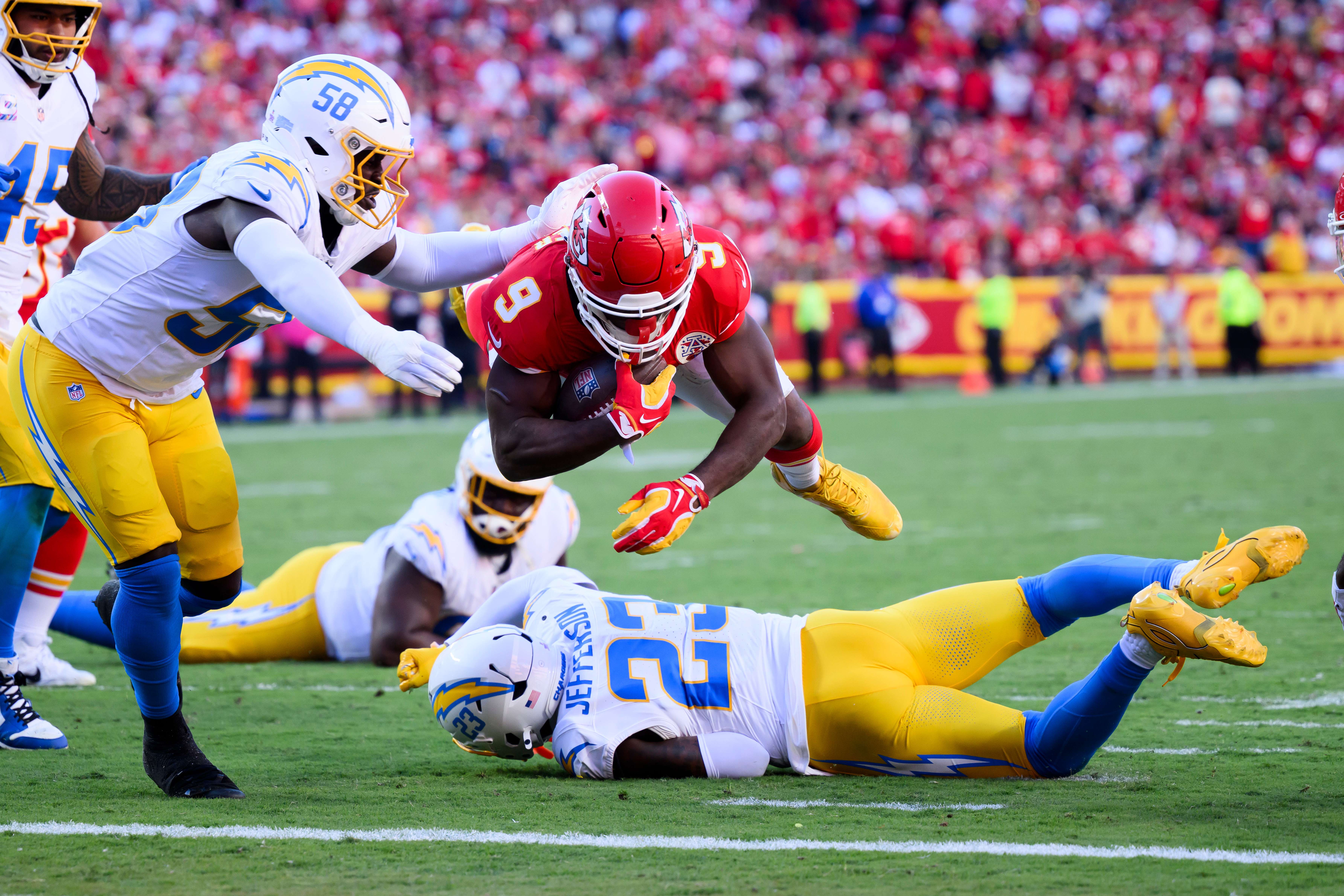 Kansas City Chiefs running back Kenneth Walker III (9) dives into the end zone for a touchdown as Los Angeles Chargers' Marlowe Wax (58) defends during the first half of an NFL football game in Kansas City, Mo., Sunday, Oct. 18, 2026. (AP Photo/Reed Hoffmann)