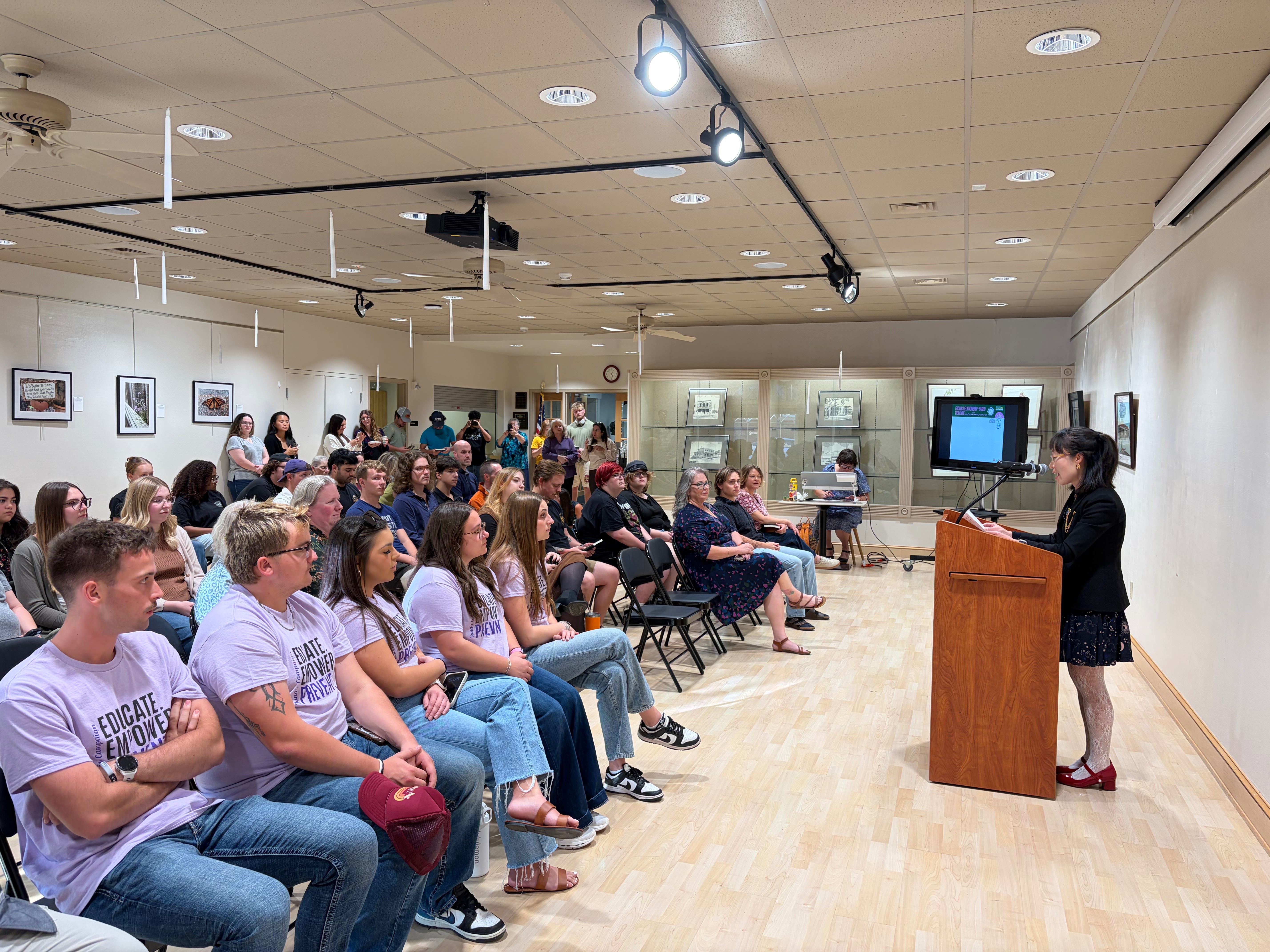 Ziewi Qi, FHSU associate professor of criminal justice and co-editor, speaking to the audience during the opening book ceremony for Relationship-Based Violence-A Rural Kansas Initiative. Photo by Alin Hett/Hays Post