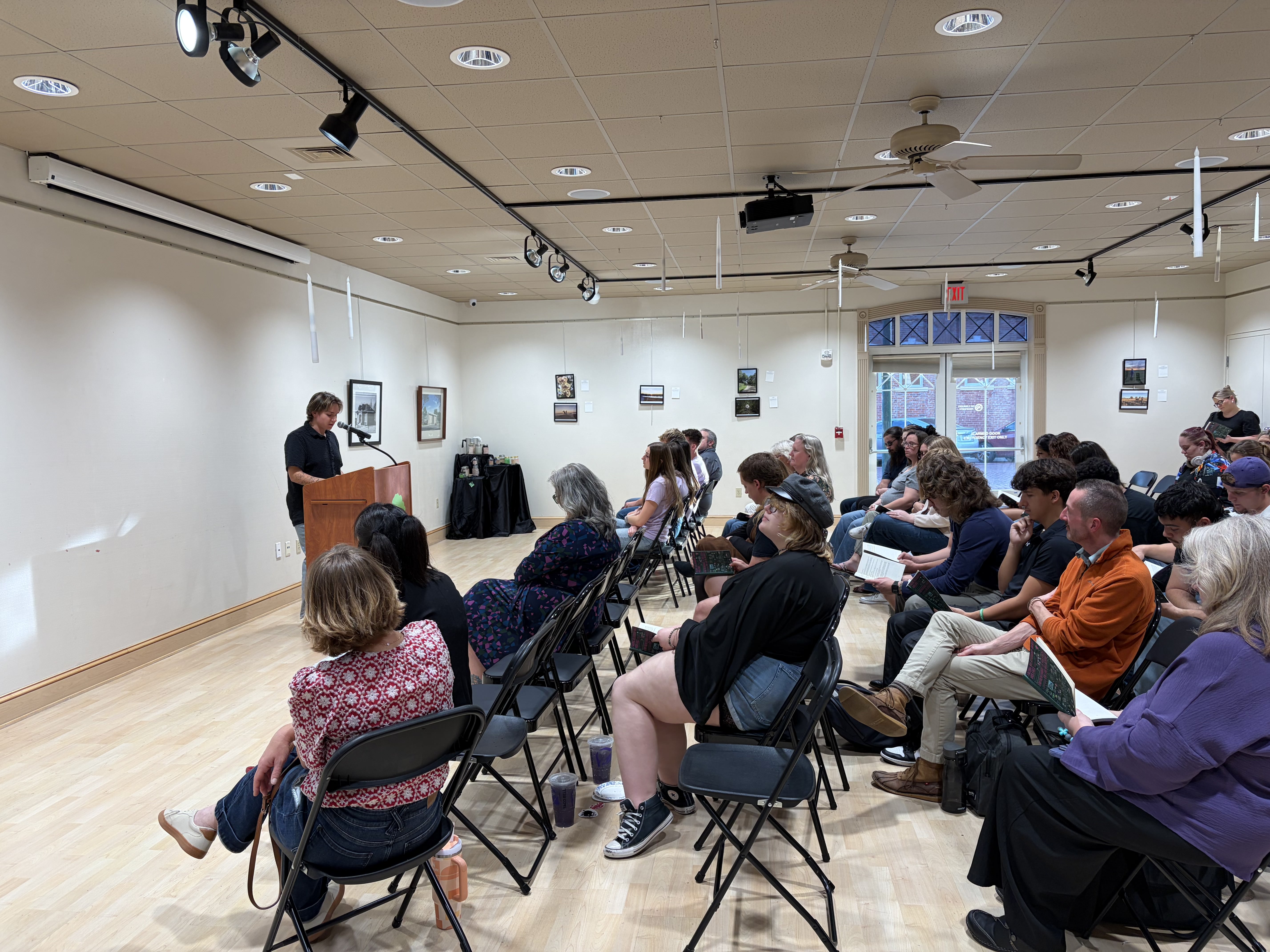 Benjamin Wilkerson, FHSU senior and one of the authors of "Relationship-Based Violence-A Rural Kansas Initiative," reads one of the personal stories to the audience. Photo by Alin Hett/Hays Post