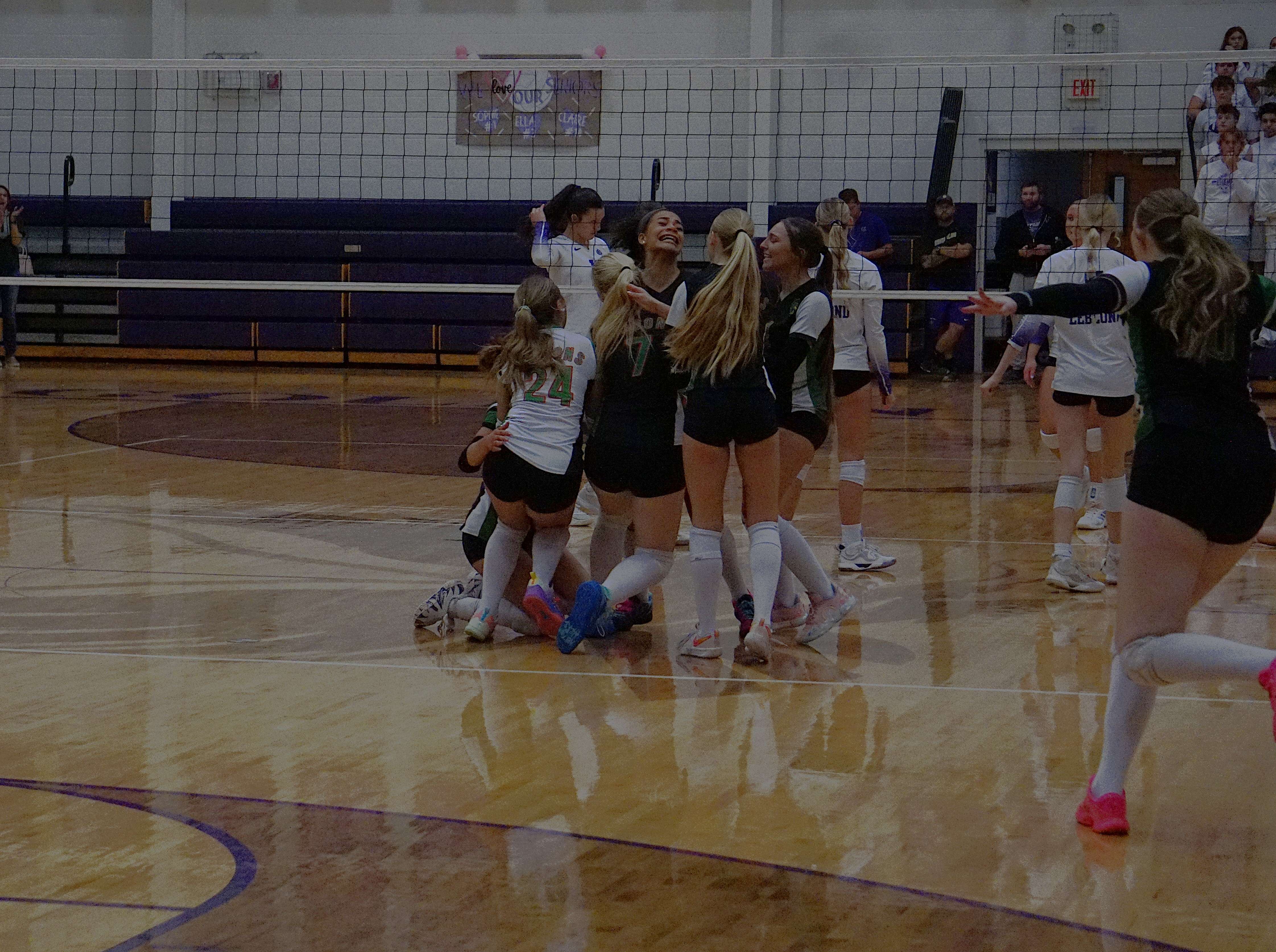 The Mid-Buchanan Dragons celebrate a victory in five sets, winning the programs first ever sectional match against Bishop LeBlond/ Photo by Matt Pike