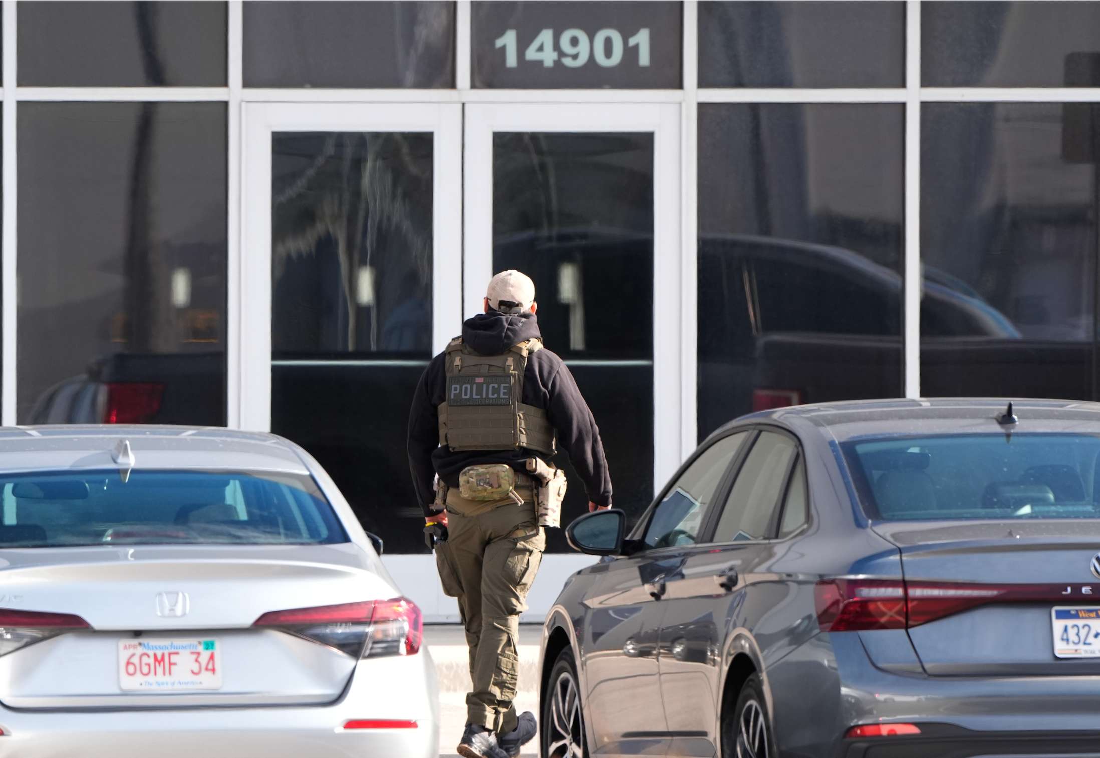 An ICE agent stands outside a warehouse as federal officials tour the facility to consider repurposing it as an ICE detention facility, Thursday, Jan. 15, 2026, in Kansas City, Mo. (AP Photo/Charlie Riedel)
