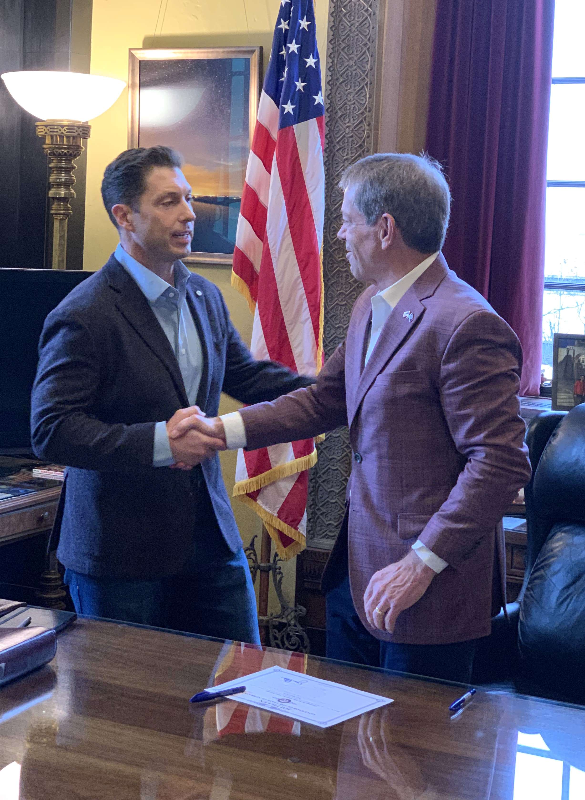 Gov. Pillen shakes Makovicka’s hand, after signing Makovicka’s certificate of appointment.