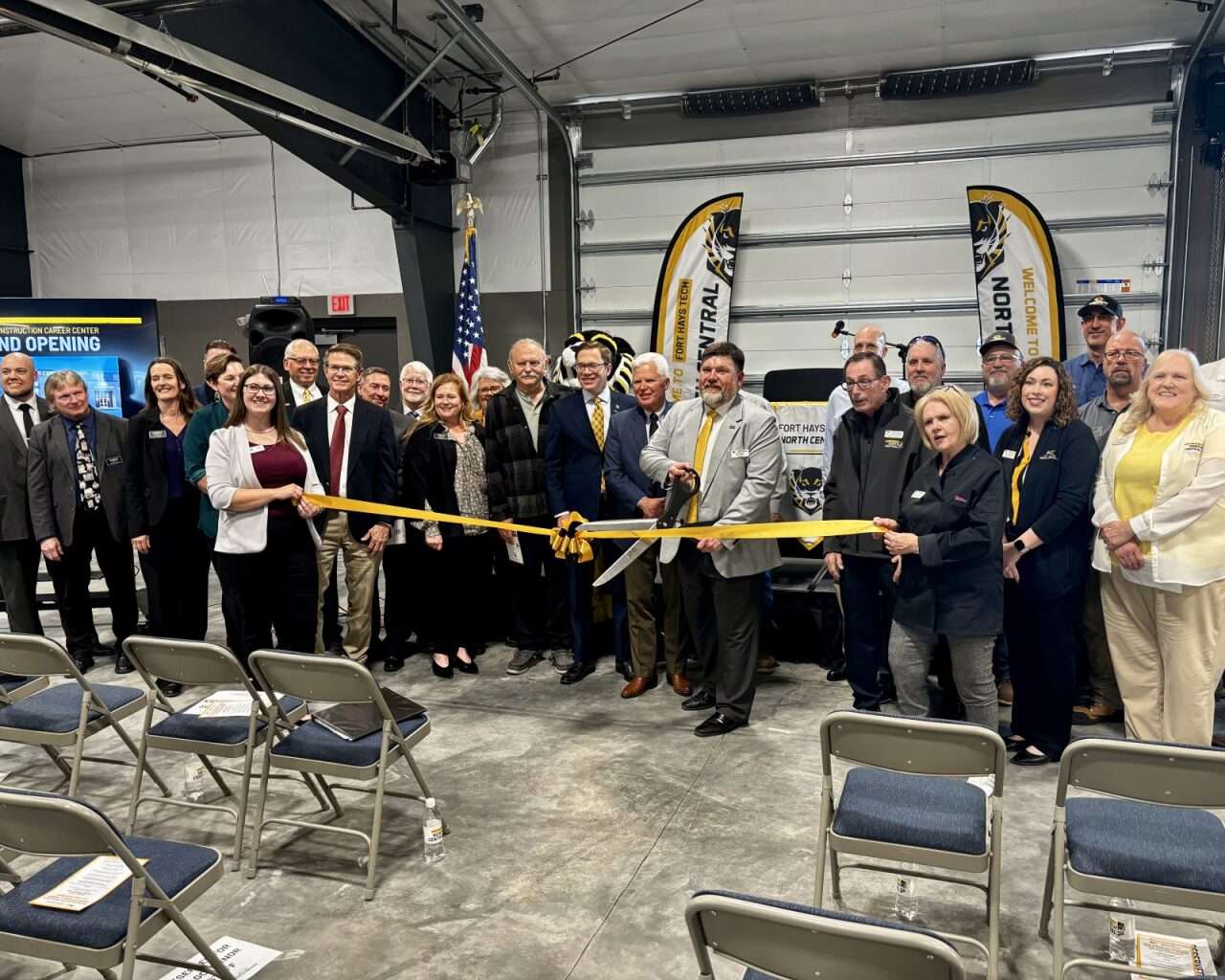 Eric Burks, Fort Hays Tech North Central president, cuts the ribbon at the Chamber in Hays celebration alongside several speakers and contributors to the new Hansen Construction Career Center. Photo by Tony Guerrero/Hays Post