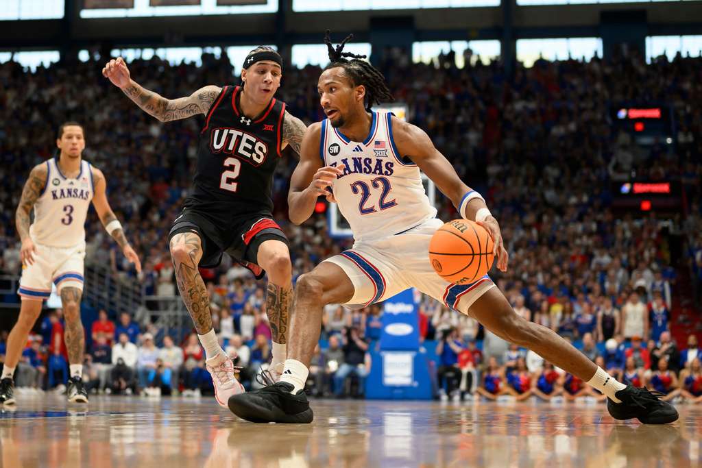 Kansas guard Darryn Peterson (22) drives against Utah guard Terrence Brown (2) during the first half of an NCAA college basketball game in Lawrence, Kan., Saturday, Feb. 7, 2026. (AP Photo/Reed Hoffmann)