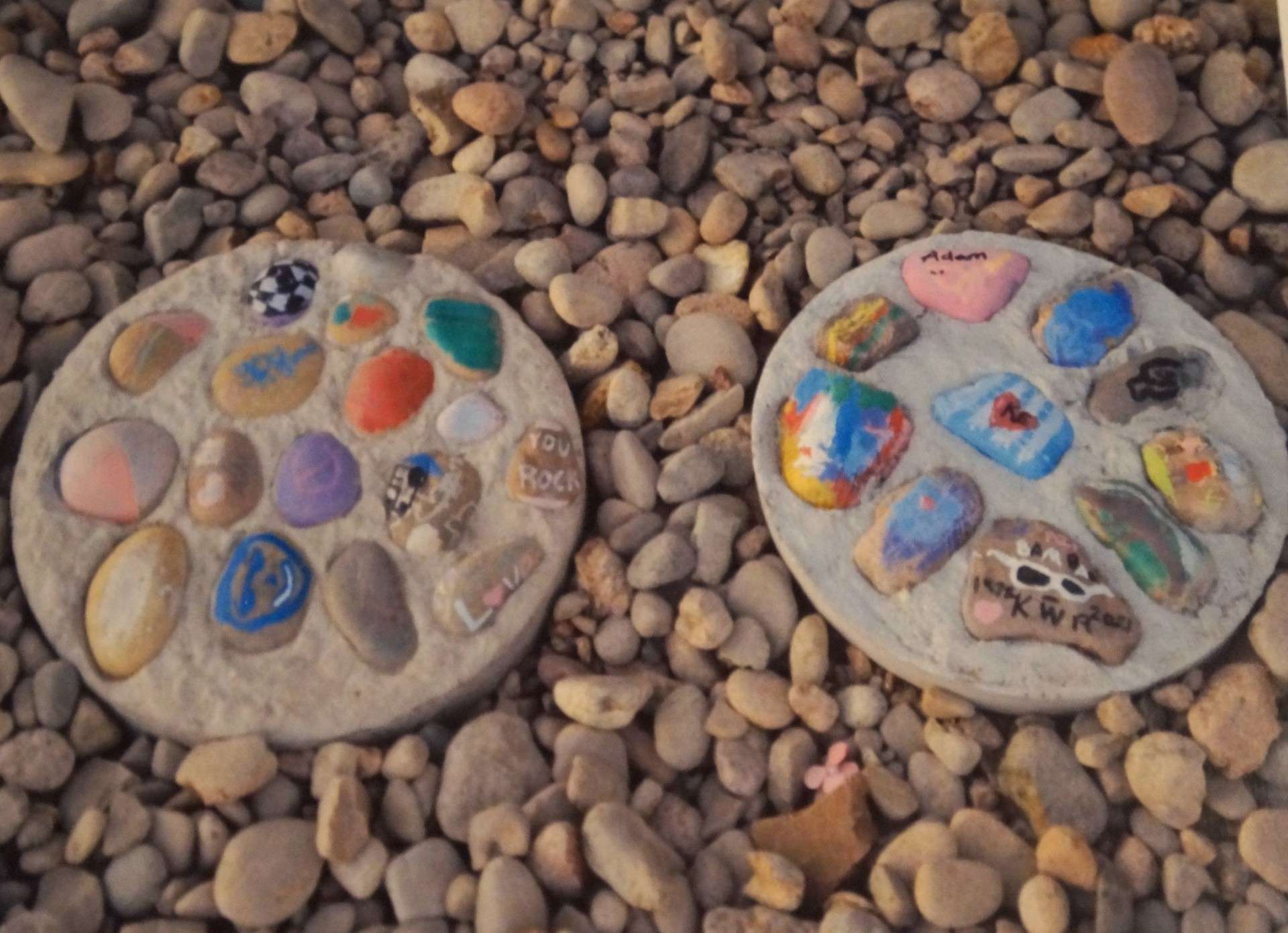 Two stepping-stones made by children at the 2024 Healing Kids’ Hearts Retreat are placed near the entrance to the Schmidt Community Center, 2510 Canterbury Dr. in Hays. Volunteers received permission to place the stones in the new location where the event will be held this year on Saturday, March 28. (Courtesy photo by Guy Windholz)
