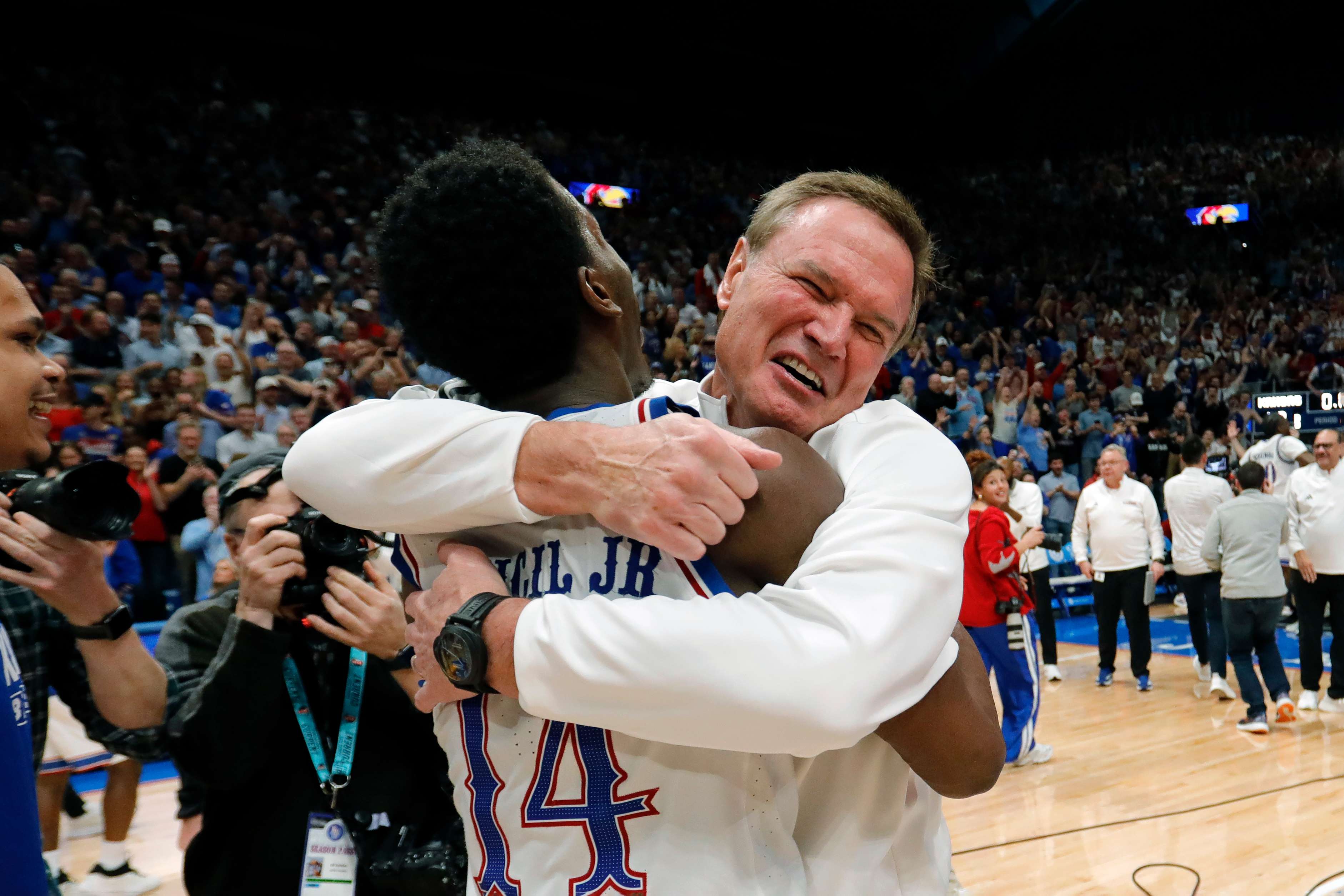 Kansas guard Melvin Council Jr. (14) is hugged by Kansas head coach Bill Self, right, as they celebrate after their team's upset over Arizona in an NCAA college basketball game, Monday, Feb. 9, 2026, in Lawrence, Kan. (AP Photo/Colin E. Braley)