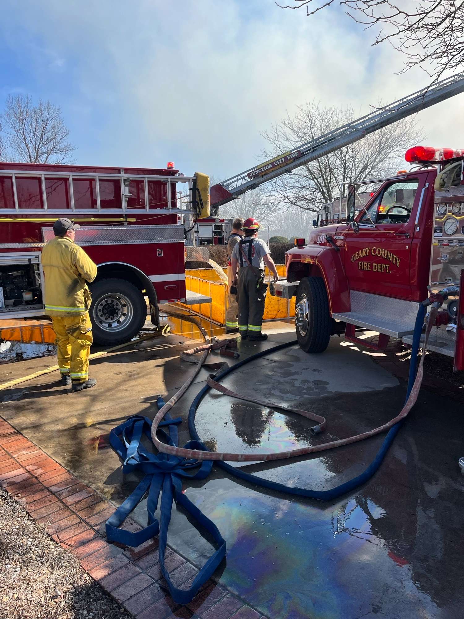 Firefighters on the scene of the house fire near K-18 highway and U.S. 77 in Junction City. As of 2:00 p.m., crews are still battling the fire, but it is now under control. (Photo - Rural Fire Chief Garry Berges).