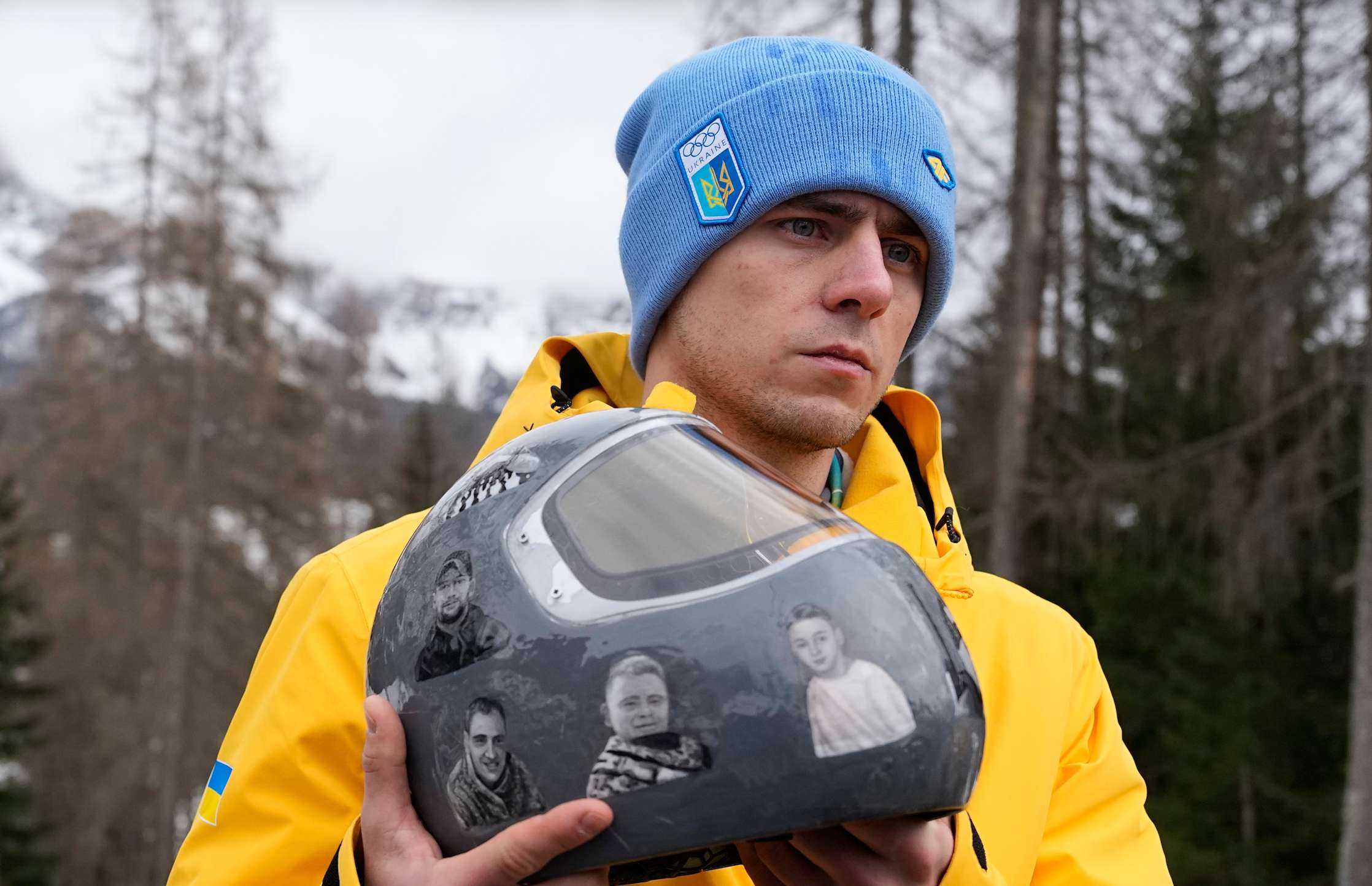 Ukrainian skeleton athlete Vladyslav Heraskevych holds his crash helmet as he stands outside the sliding center at the 2026 Winter Olympics, in Cortina d'Ampezzo, Italy, Thursday, Feb. 12, 2026. (AP Photo/Alessandra Tarantino)