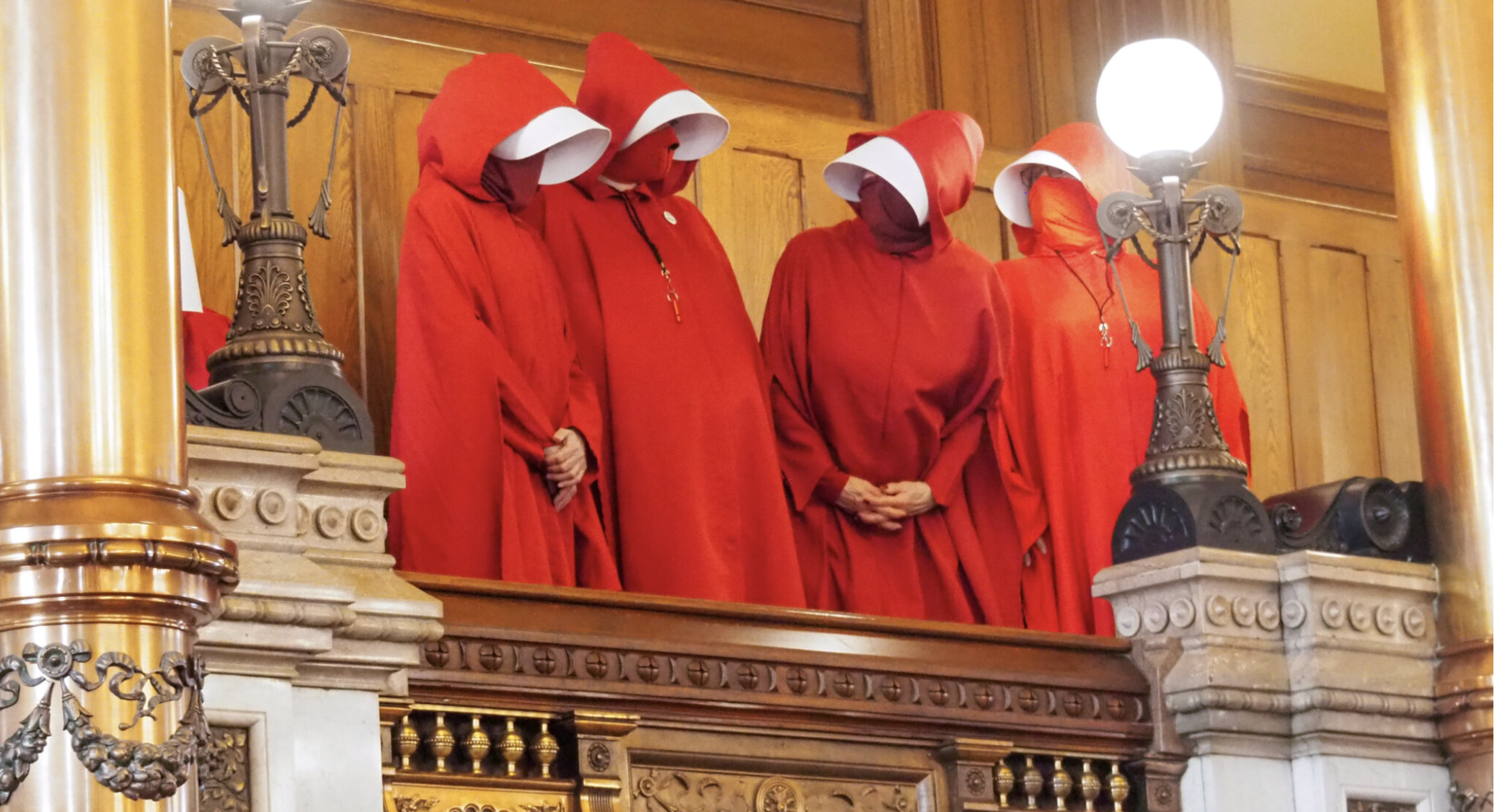  Protesters adorned with clothing reminiscent of “the Handmaid’s Tale” carried cloth signs labeled “Shame” as they challenged Kansas legislators Monday at the Kansas Capitol to enact policies for benefit of Kansans rather than follow a path toward theocratic government. (Photo by Tim Carpenter/Kansas Reflector)
