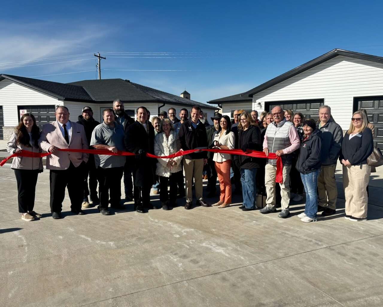 Russell, state and Housing Opportunities Inc. officials celebrating the near completion of the Flintwood Senior Housing project with a ribbon-cutting on Friday. Photo by Tony Guerrero/Hays Post