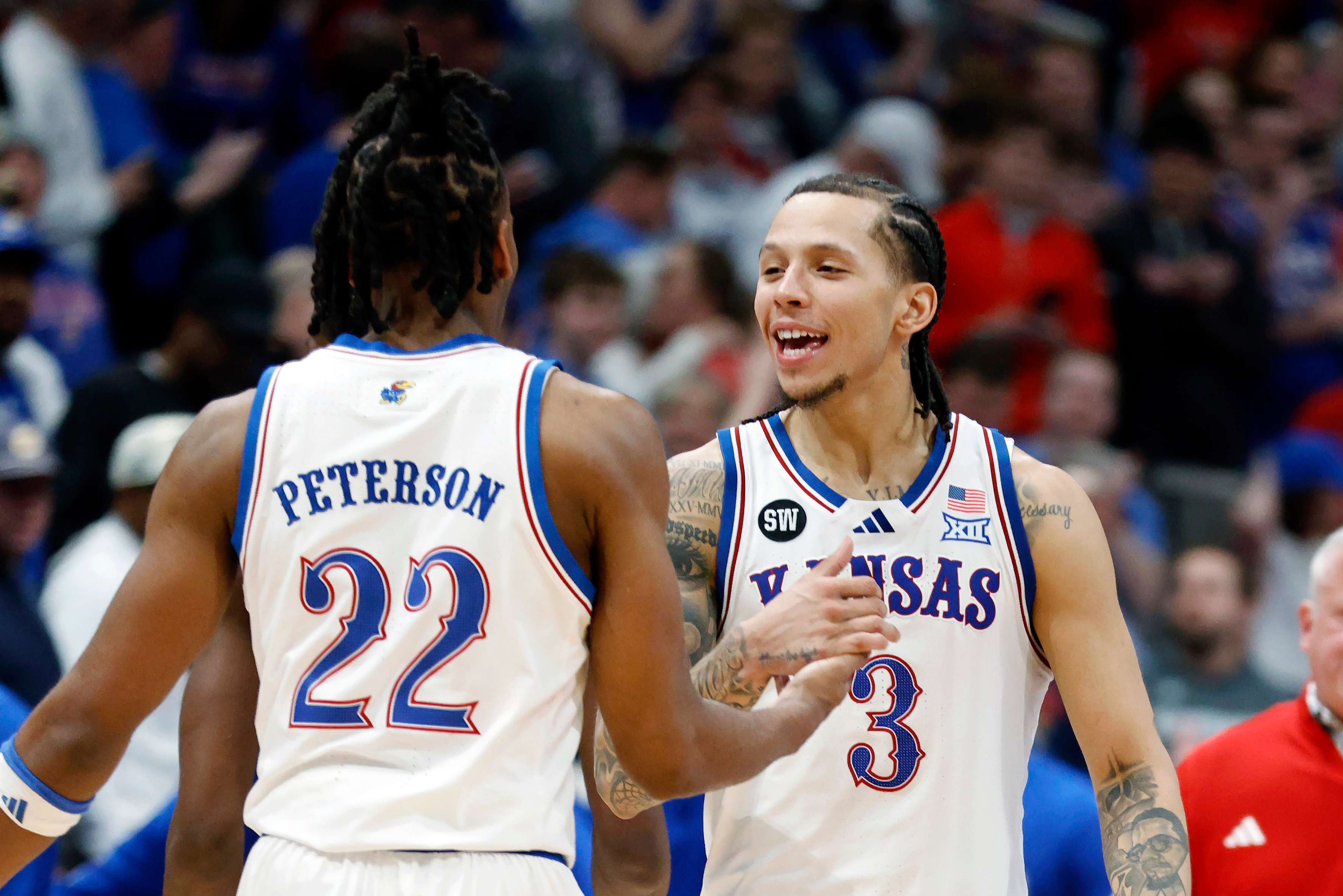 Kansas guards Tre White (3) and Darryn Peterson (22) celebrate after an NCAA college basketball game against Houston, Monday, Feb. 23, 2026, in Lawrence, Kan. (AP Photo/Colin E. Braley)
