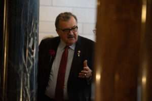 State Sen. Mike Jacobson of North Platte speaks with colleagues off the legislative floor. (Zach Wendling/Nebraska Examiner)