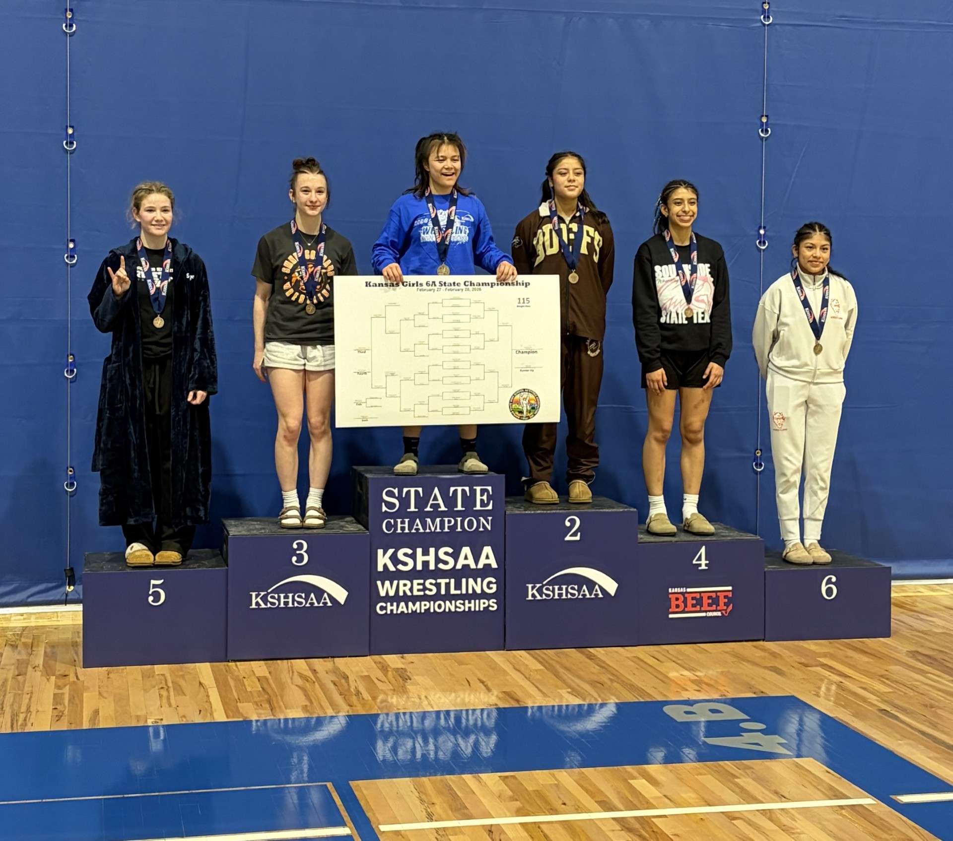 Junction City senior Bree Villanueva stands at the top of the podium as the State Champion for 115 lbs. in class 6A girls wrestling.