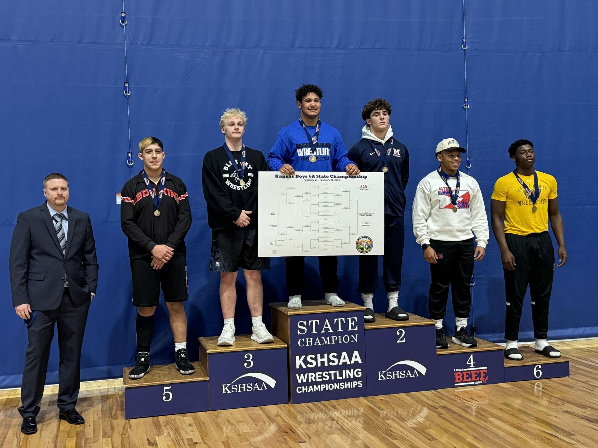 Junction City senior Chris Coy stands on the podium with a third place finish in weight class 215 lbs. at the Class 6A State Tournament.