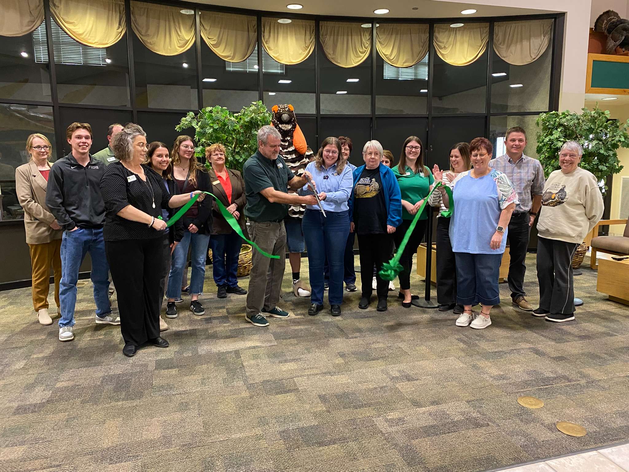 Jackie Augustine, executive director of the Audubon of Kansas, and Reese Barrick, executive director of the Sternberg Museum, cut the ribbon at a Chamber ribbon-cutting celebrating the fifth-annual Lek Trek prairie-chicken festival that will be April 9 to 12 in Hays. Photo by Cristina Janney/Hays Post