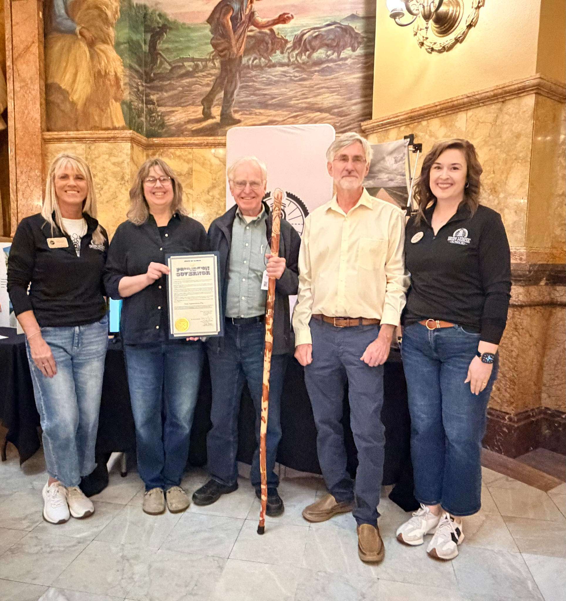 <b>Pictured left to right:</b> Elizabeth Weese, Community Foundation of Dickinson County; Kristine (Minick) Sommers; Joe Minick holding his award, a personalized walking stick; Dan Minick; and Julie Roller Weeks, Abilene Convention and Visitors Bureau. Courtesy photo.
