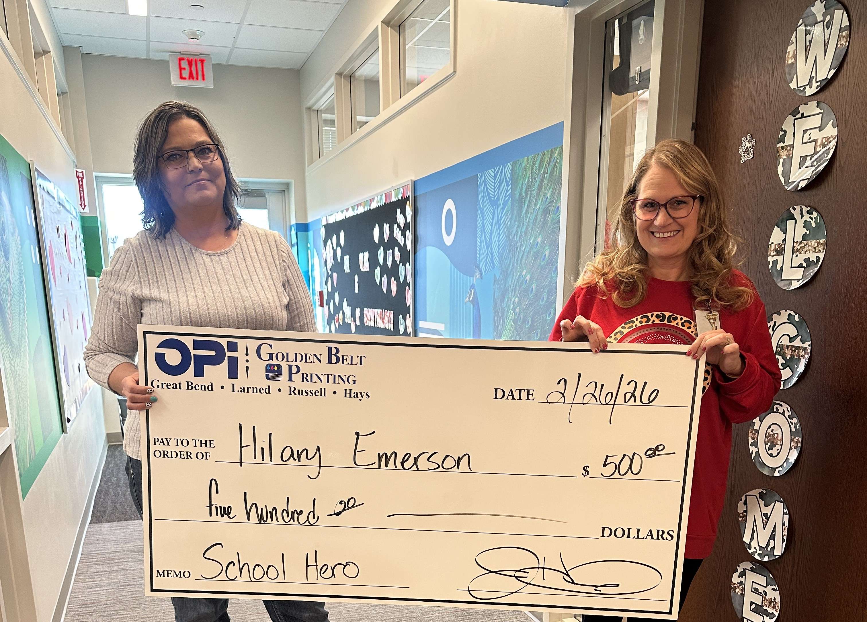 Hilary Emerson, a special education teacher at Little Panthers Preschool in Great Bend, was presented a giant $500 check from OPI &amp; Golden Belt Printing as the February winner in Eagle Media's School Hero Contest.